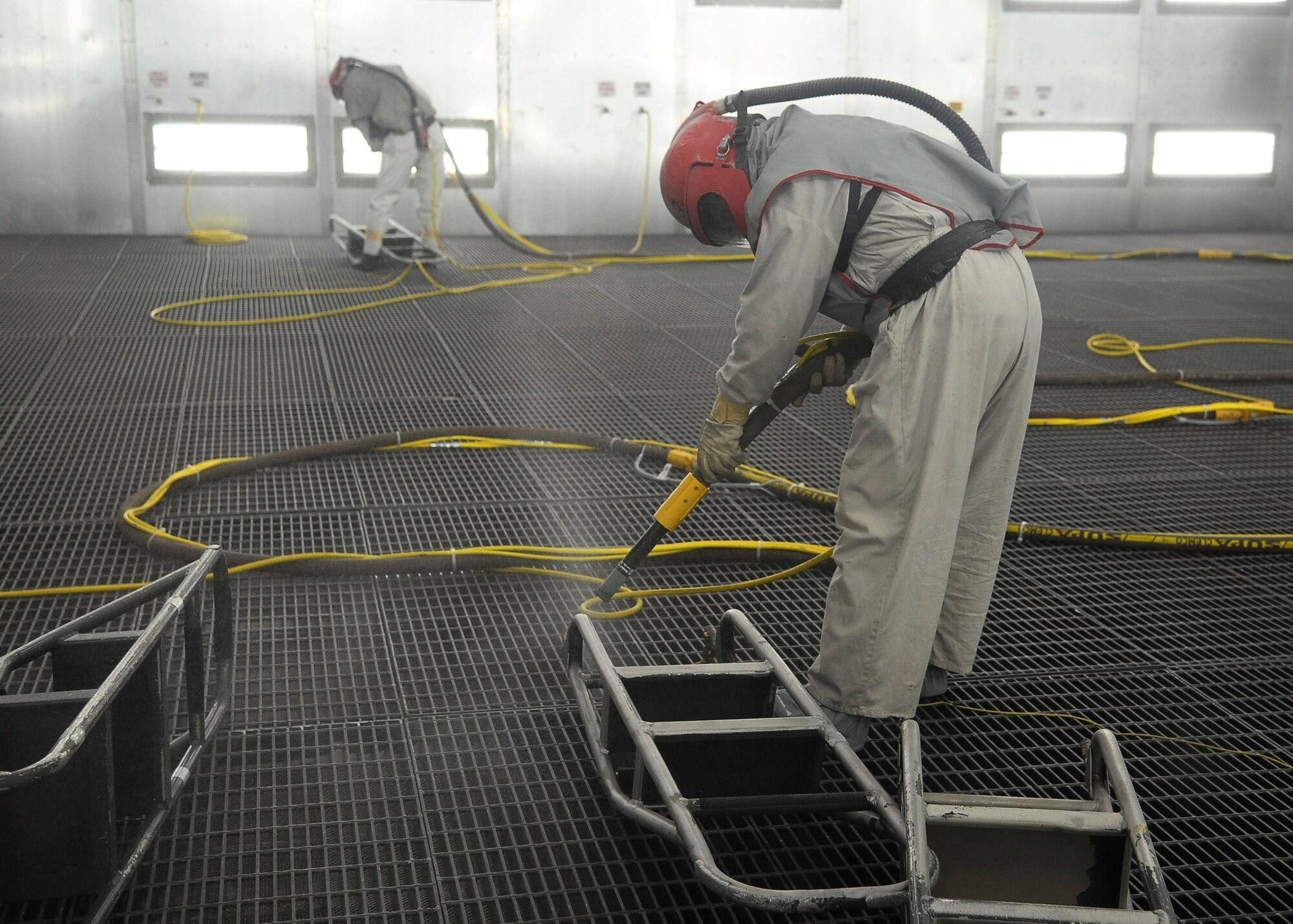 Robert Wilson III, corrosion control worker, tests the new blasting facility August 9. The blasting facility will allow workers to strip paint in an environmentally-friendly way for the more than 500 Air Force and Navy aircraft that the base services. To avoid being too heavy, each plane must be stripped of its old paint before it can be repainted. The aircraft are repainted every three to four years to prevent corrosion. The upgraded facility will increase production by 44 percent and save approximately $150,000. (U.S. Air Force Photo/Airman 1st Class Stephanie Englar)