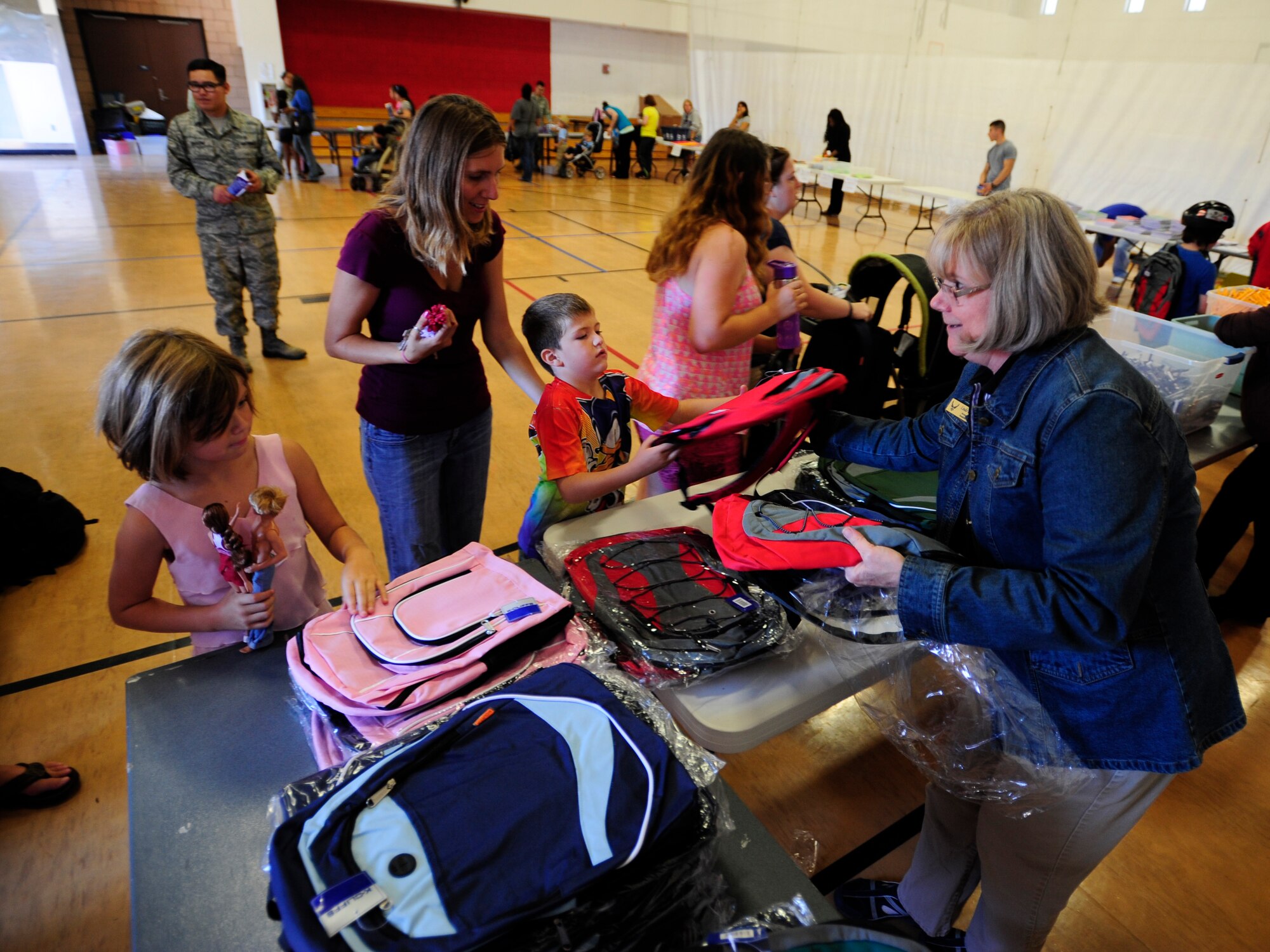 VANDENBERG AIR FORCE BASE, Calif. – Linda Crowder, Airmen and Family Readiness acting director, gives out backpacks as part Backpack Brigade during Salute to Youth event here Thursday, August 15, 2013. Salute to Youth was both an educational and family friendly event. It hosted the Exceptional Family Member Program, local schools, Backpack Brigade, food, games and prizes. (U.S. Air Force photo/Airman Yvonne Morales)