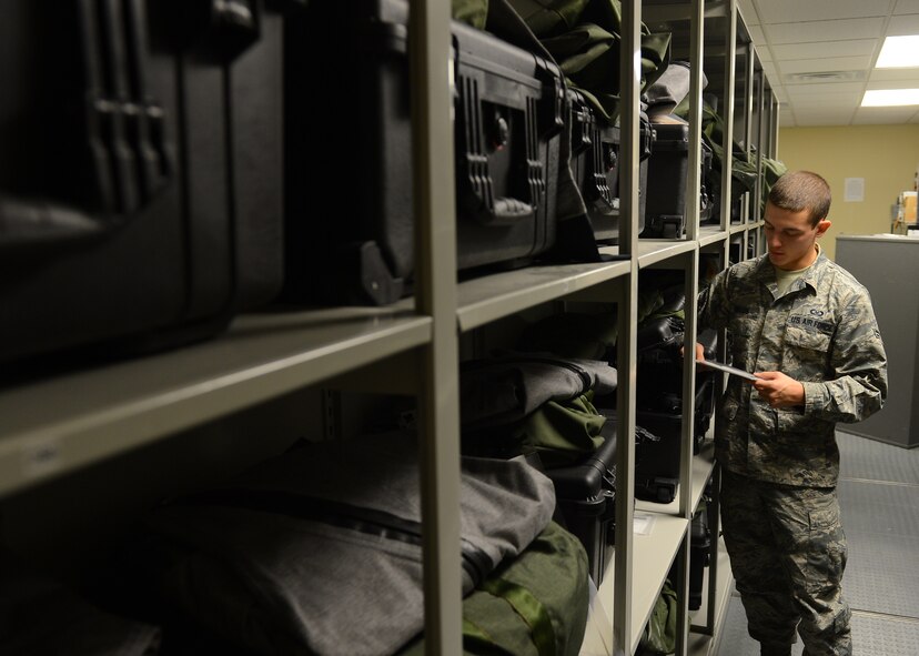 Airman 1st Class Michael Fields, 2nd Operations Support Squadron flight equipment journeyman, inspects chemical bags and over-the-side suits on Barksdale Air Force Base, La., Aug. 16, 2013. Chemical bags contain special chemical gear for aircrew so they can survive in contaminated envrionments. The OTS suit keeps crew members warm in the event of a water landing. (U.S. Air Force photo/Senior Airman Micaiah Anthony)