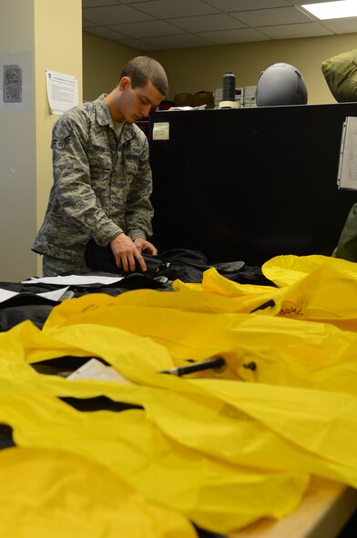 Airman 1st Class Michael Fields, 2nd Operations Support Squadron flight equipment journeyman, prepares a life preserver unit on Barksdale Air Force Base, La., Aug. 16, 2013. Life preserver units are equipped with water-activated inflators to save incapacitated aircrew from drowning. (U.S. Air Force photo/Senior Airman Micaiah Anthony)