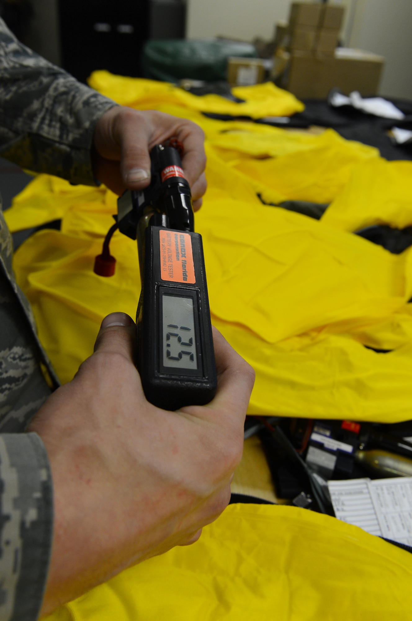Airman 1st Class Michael Fields, 2nd Operations Support Squadron flight equipment journeyman, checks the voltage of an FLU-9B/P on Barksdale Air Force Base, La., Aug. 16, 2013. In order to pass the inspection, the voltage must be above 12 volts direct current. The FLU-9B/P is used to inflate aircrew's life preserve vests in the event of an emergency. (U.S. Air Force photo/Senior Airman Micaiah Anthony)