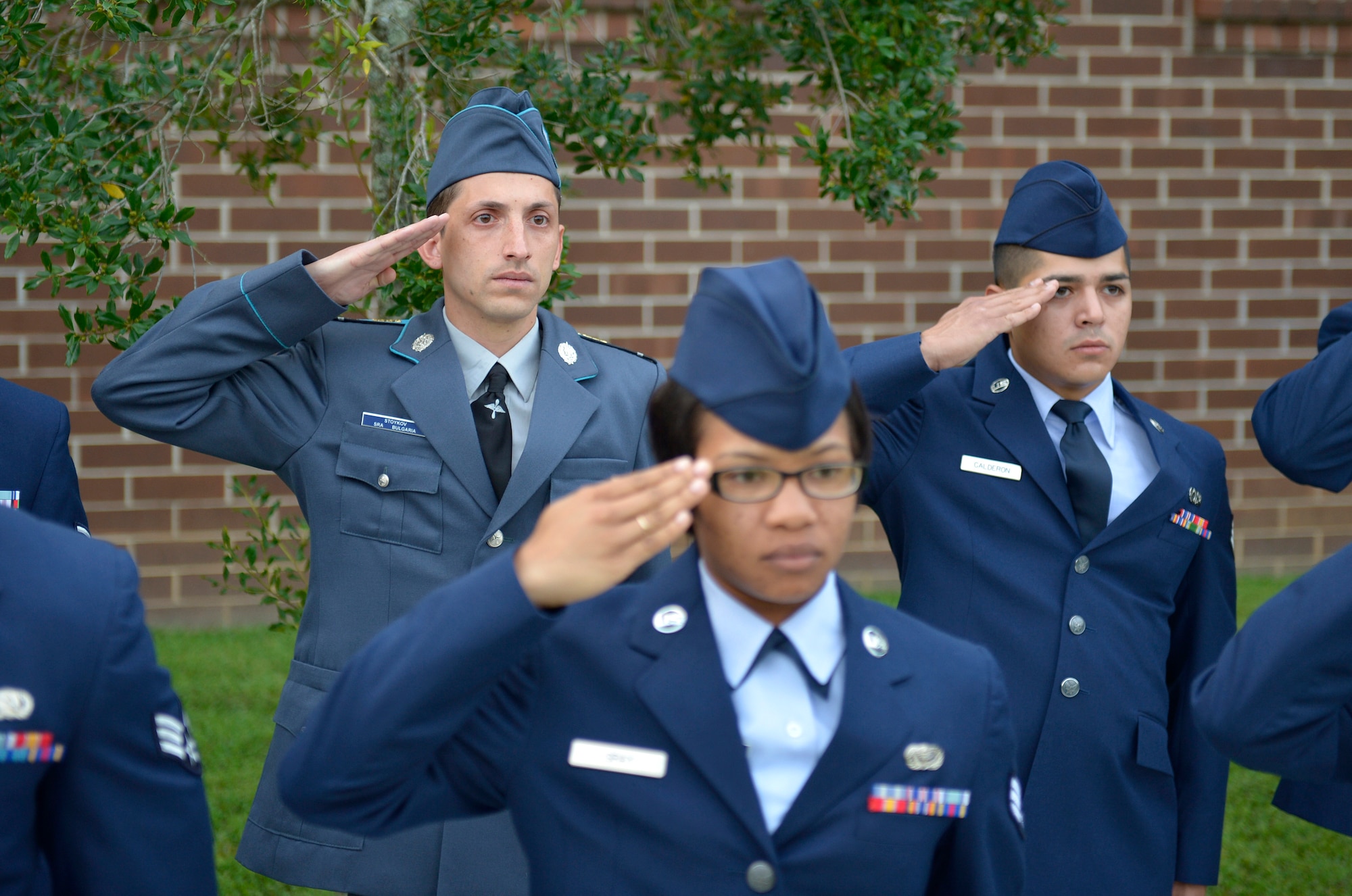 MCGHEE TYSON AIR NATIONAL GUARD BASE, Tenn. - Corporal Stoyko V. Stoykov with the Bulgarian air force salutes with U.S. Air Force members and classmates here August 15, 2013, during a reveille ceremony at the I.G. Brown Training and Education Center. Stoykov graduated from the U.S. Air Force Airman Leadership School, instructed by the Paul H. Lankford Enlisted PME Center, along with Bulgarian Sergeant Yordanka S. Petrova-Angelova, who graduated from the Noncommissioned Officer Academy, as a result of international relations built through the Tennessee National Guard State Partnership Program.  (U.S. Air National Guard photo by Master Sgt. Kurt Skoglund/Released)