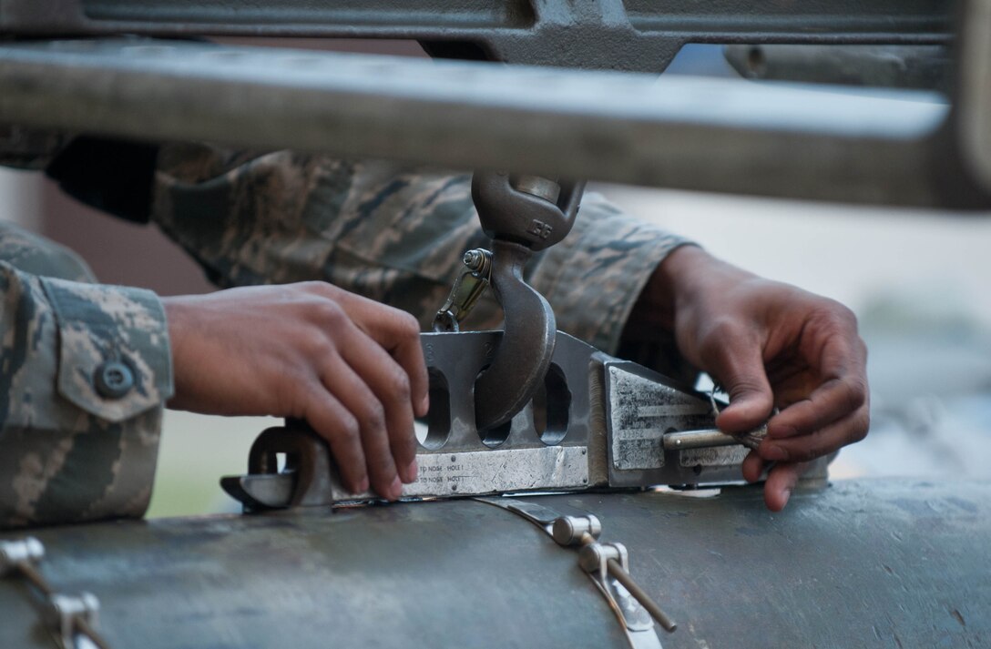 Airman 1st Class Michael Bryant, 28th Aircraft Maintenance Squadron weapons load crew member, secures an inert guided bomb unit to a mobile lift to prepare for real-world scenarios in the Load Crew Training Facility at Ellsworth Air Force Base, S.D., Aug. 13, 2013. Ellsworth weapons load crews prepare and train monthly to stay proficient in the handling and transportation of munitions for missions downrange. (U.S. Air Force photo by Airman 1st Class Zachary Hada/Released)