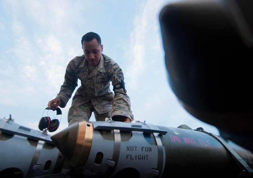 Airman 1st Class Michael Bryant, 28th Aircraft Maintenance Squadron weapons load crew member, inspects inert guided bomb units prior to loading them into a B-1 bomber mock trainer in the Load Crew Training Facility at Ellsworth Air Force Base, S.D., Aug. 13, 2013. Guided bomb units are 500-pound precision strike, satellite guided munitions that deliver accurate strikes against moving and stationary targets. (U.S. Air Force photo by Airman 1st Class Zachary Hada/Released)