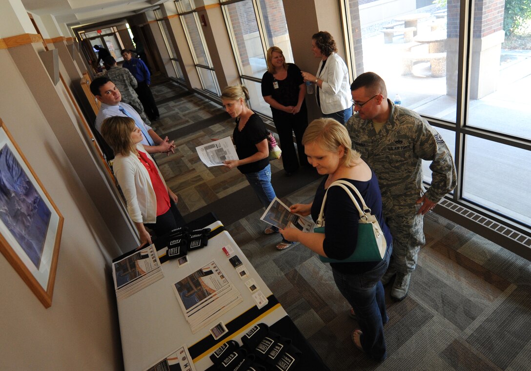 Airmen, family members and civilians visit information booths during an education fair in the Rushmore Center at Ellsworth Air Force Base, S.D., Aug. 14, 2013. The fair was designed to provide attendees with an opportunity to explore and learn more about the many colleges offering courses in the area during the upcoming fall semester. (U.S. Air Force photo by Airman 1st Class Hrair H. Palyan/Released)
