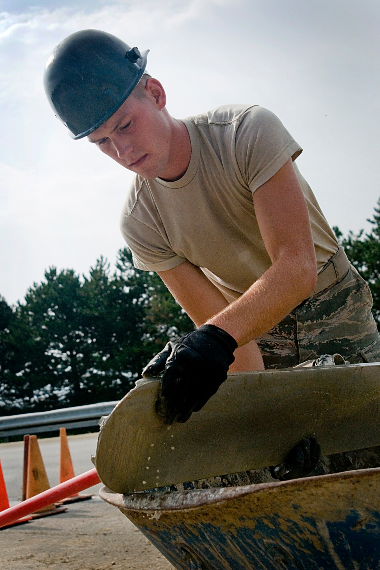 Senior Airman Edward Black, 434th Civil Engineer Squadron pavements and construction equipment apprentice, washes the cement off a trowel Aug 8, 2013 at Grissom Air Reserve Base, Ind. Black and other CES members spent 12 days training here and expanded the patio between the 434th Maintenance Group command section and the base exchange at Bldg. 595. (U.S. Air Force photo/Tech. Sgt. Doug Hays)