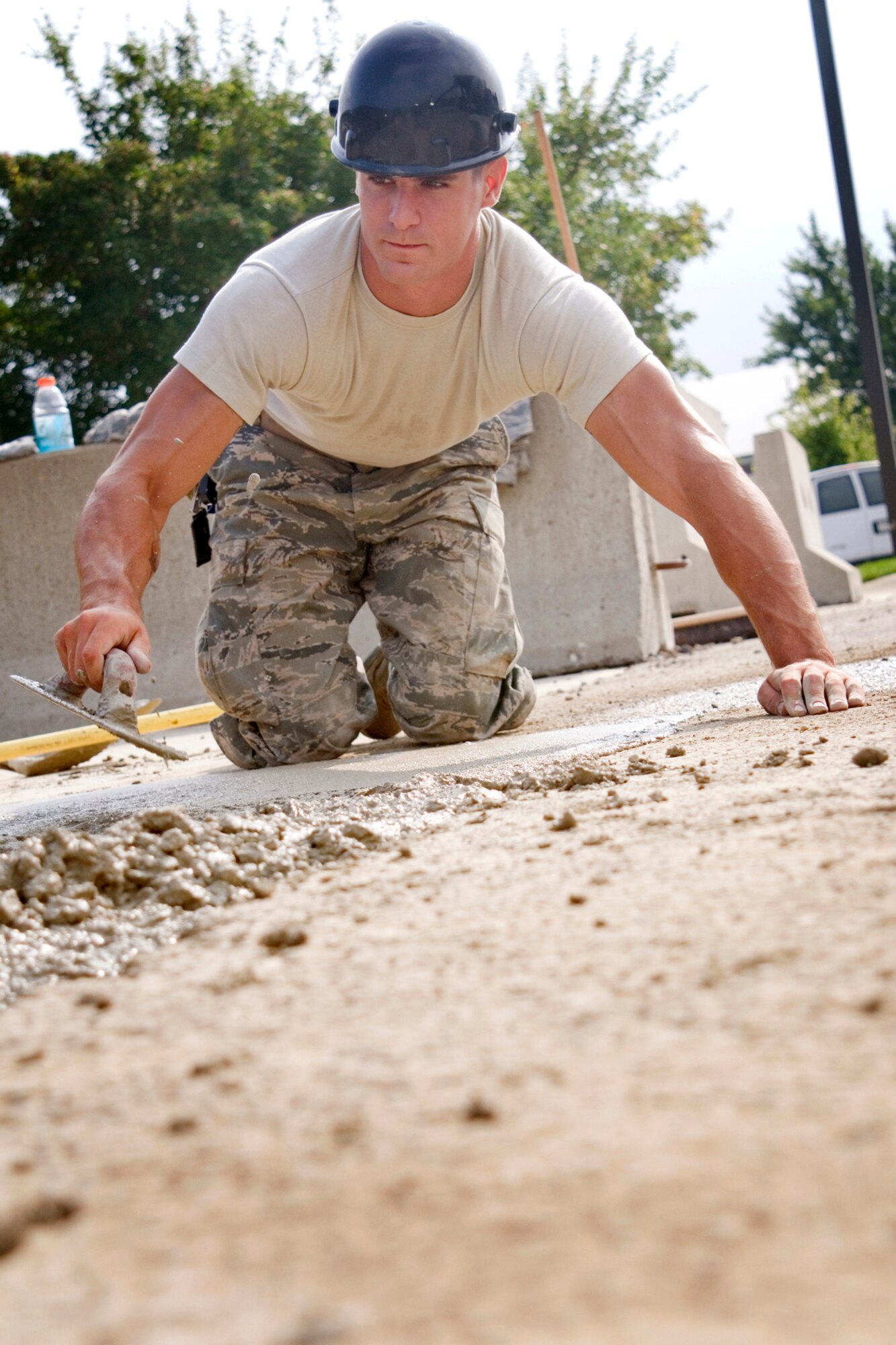 Senior Airman Alex Barone, 434th Civil Engineer Squadron pavements and construction equipment apprentice, uses a trowel to smooth cement Aug. 8, 2013 at Grissom Air Reserve Base, Ind. Members of the 434th CES trained at the base expanding a patio area between the 434th Maintenance Group command section and the base exchange at Bldg. 595. (U.S. Air Force photo/Tech. Sgt. Doug Hays)