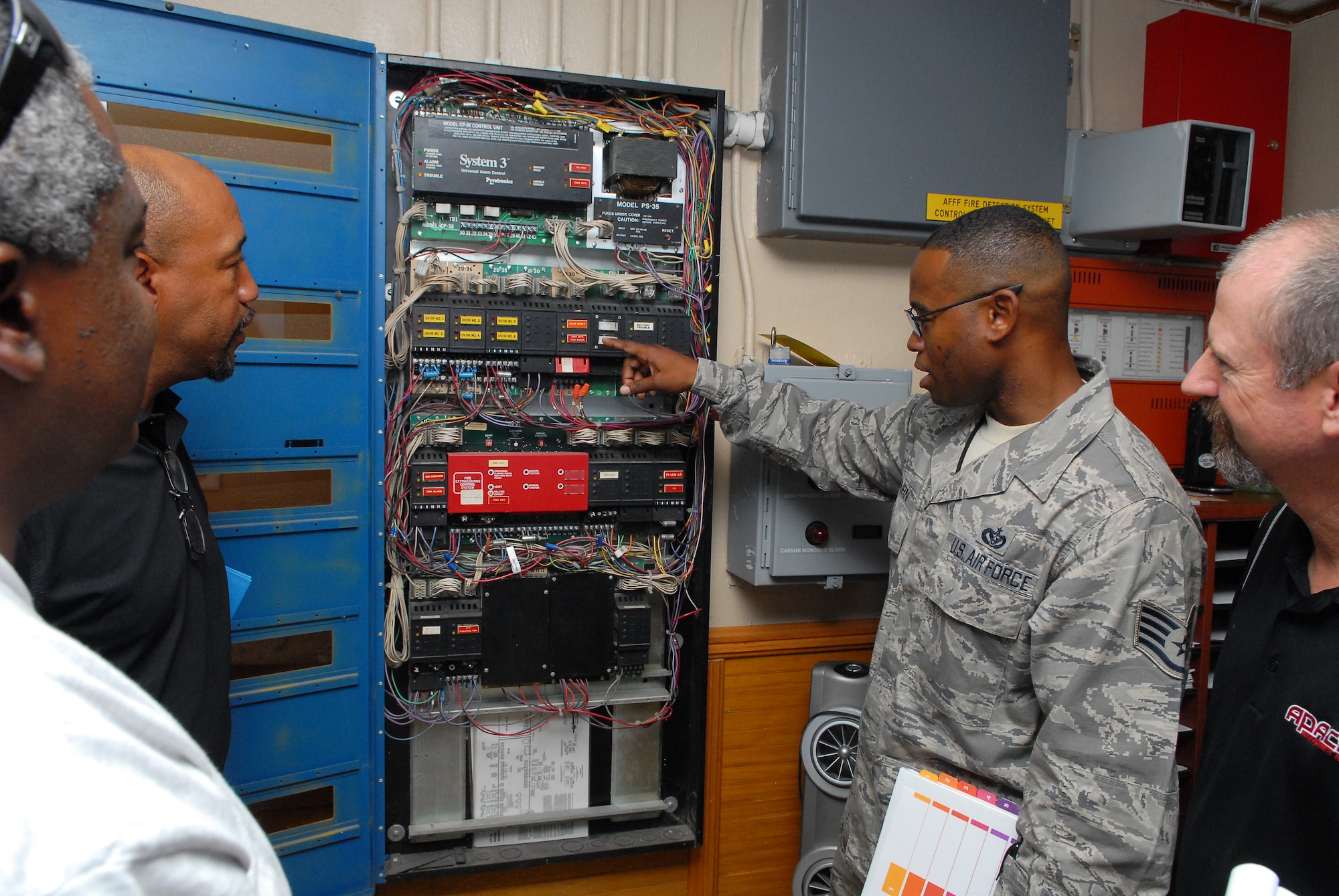 Staff Sgt. Delbert Coburn, 56th Civil Engineer Squadron electrical systems journeyman, talks about a Siemens fire alarm suppression system for an F-16 maintenance hangar in Bldg. 968 during a site survey. The survey was for a project to replace the existing fire alarm suppression system with an updated system. (U.S. Air Force photo/Senior Airman David Owsianka)