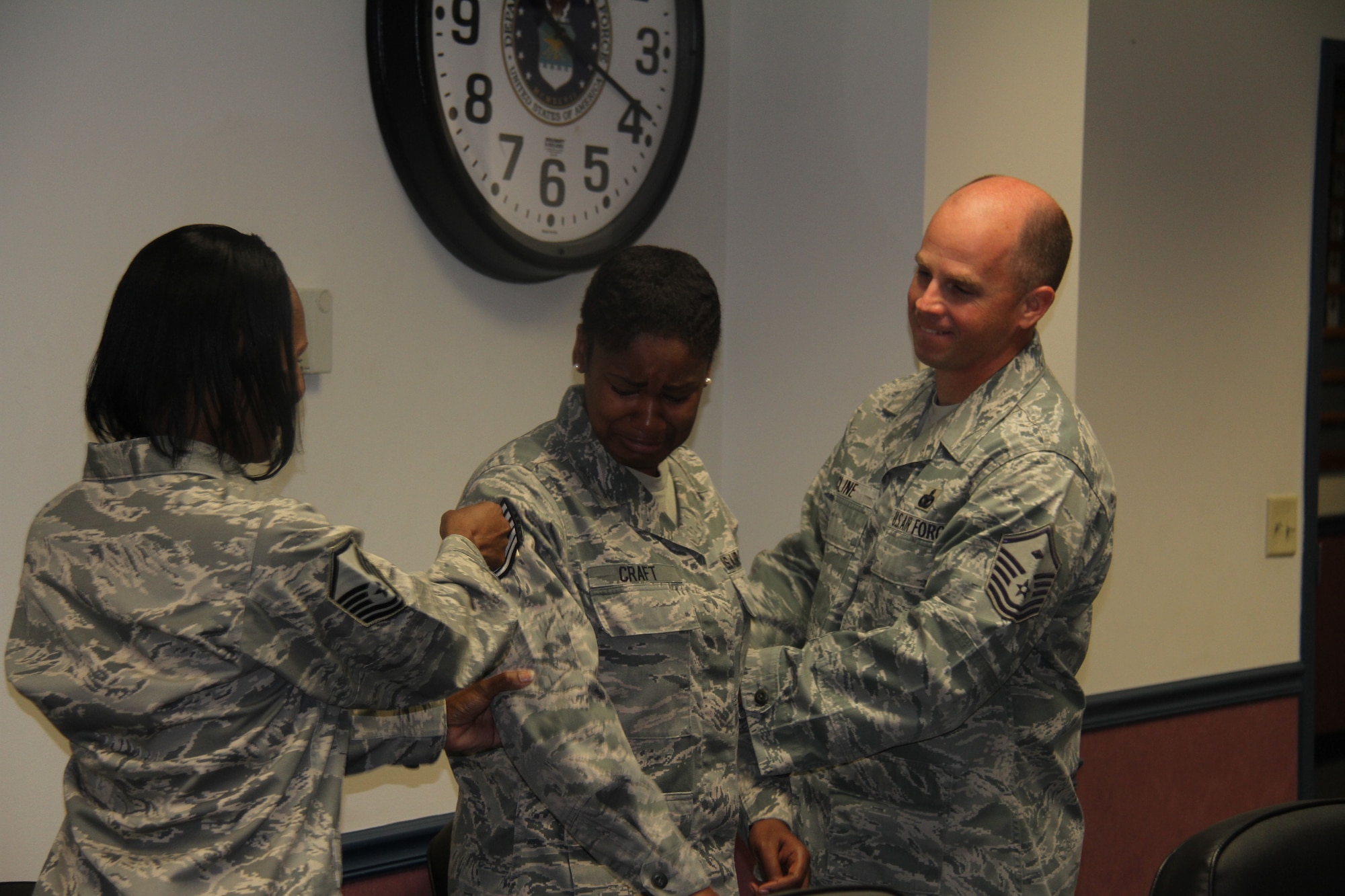 Master Sgt. Michael Cline, 345th RCS first sergeant (right), and Master Sgt. Sherica Harris, 345th RCS NCO in charge of personnel programs (left), tacks on technical sergeant stripes for Staff Sgt. Sharron Craft July 31. Craft, a 345th Recruiting Squadron operations noncommissioned officer (center), was promoted to technical sergeant through the Stripes for Exceptional Performers program. . (U.S. Air Force photo/Tech. Sgt. Daniel Hopper)