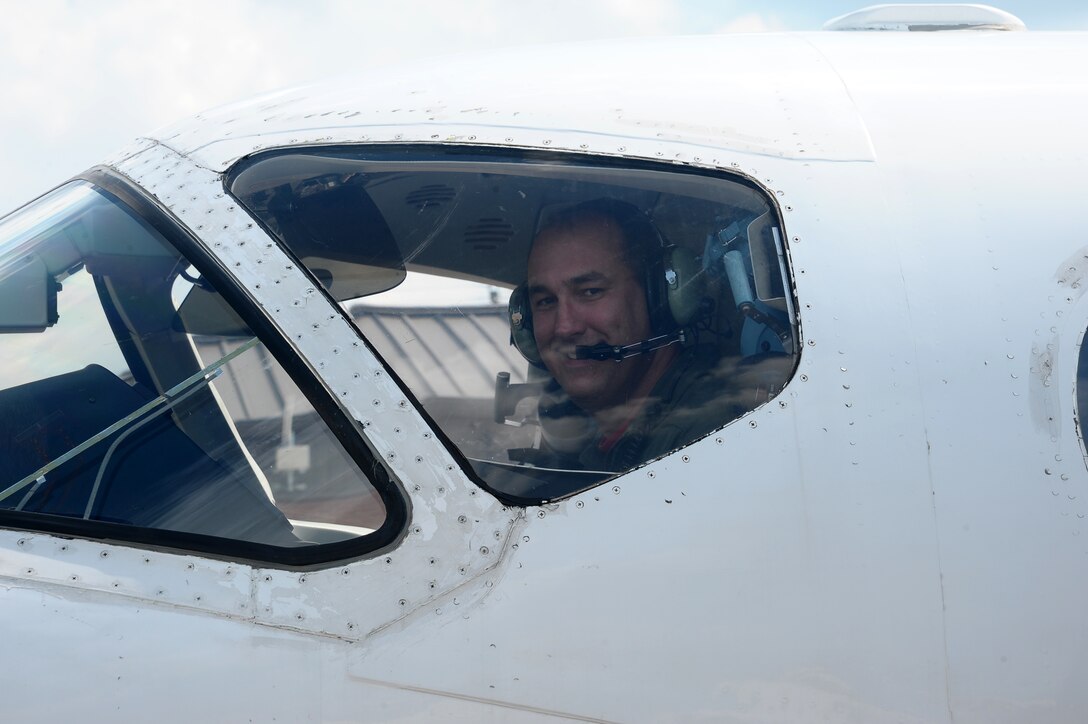 Lt. Col. Barry Tye, 43rd Flying Training Squadron, glances out the window of a T-1A Jayhawk after landing from his fini-flight Aug. 14 on the Columbus Air Force Base flight line. The fini-flight is a military aviation tradition and here marked Tye’s retirement from the Air Force upon completion of his final flight on Columbus AFB. Upon completion of the fini-flight, it is tradition to spray down or douse the pilot in water upon leaving the aircraft. (U.S. Air Force Photo/Airman 1st Class Stephanie Englar)