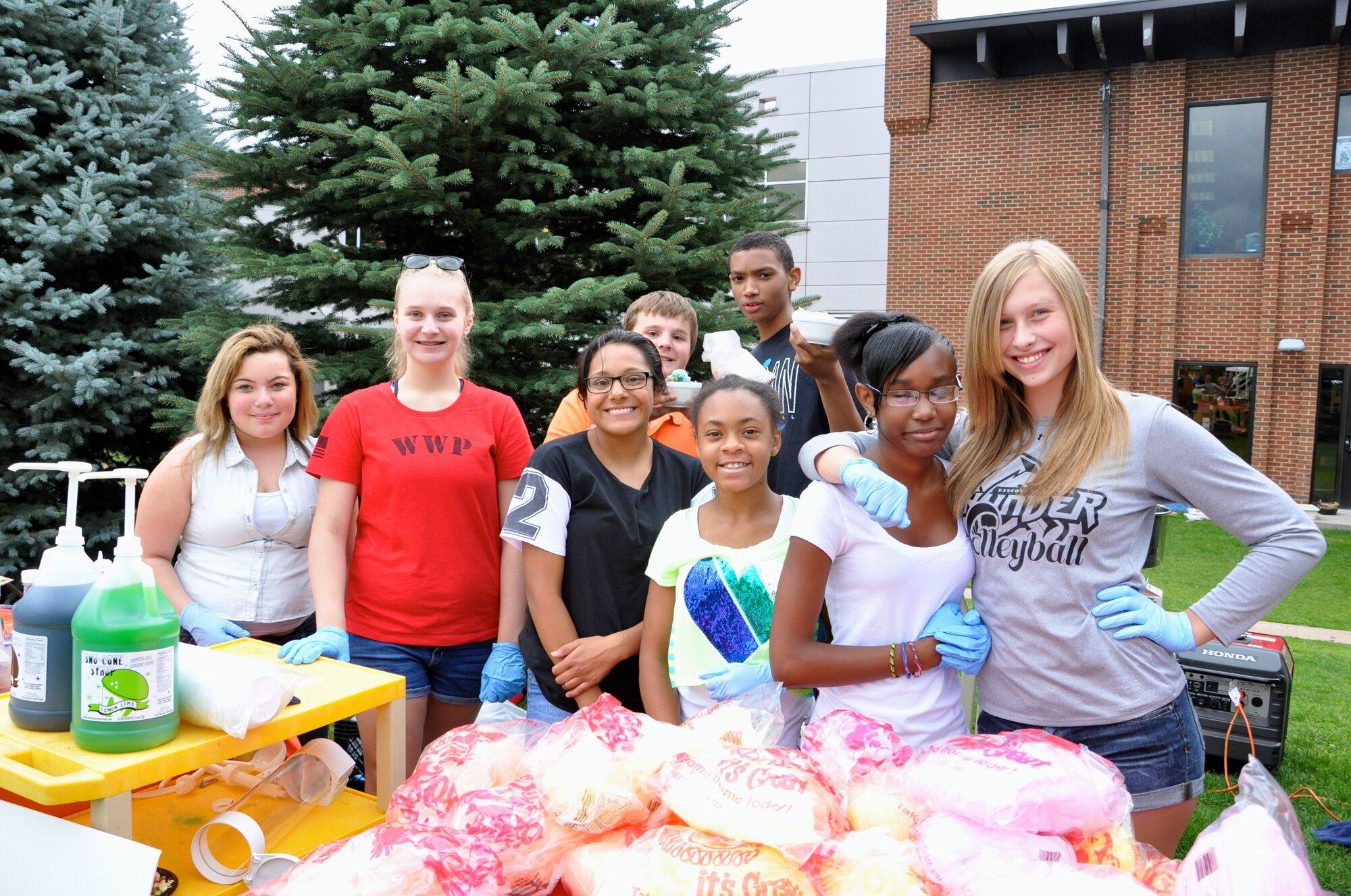 PETERSON AIR FORCE BASE, Colo. – Volunteers from the R.P. Lee Youth Center’s Keystone Club serve shaved ice and cotton candy during the Family Festival and Deployed Families Dinner Aug. 9 at Patriot Park. The dinner and festival included free food, music and carnival activities for all members of Team Pete. (U.S. Air Force photo/1st Lt. Stacy Glaus)