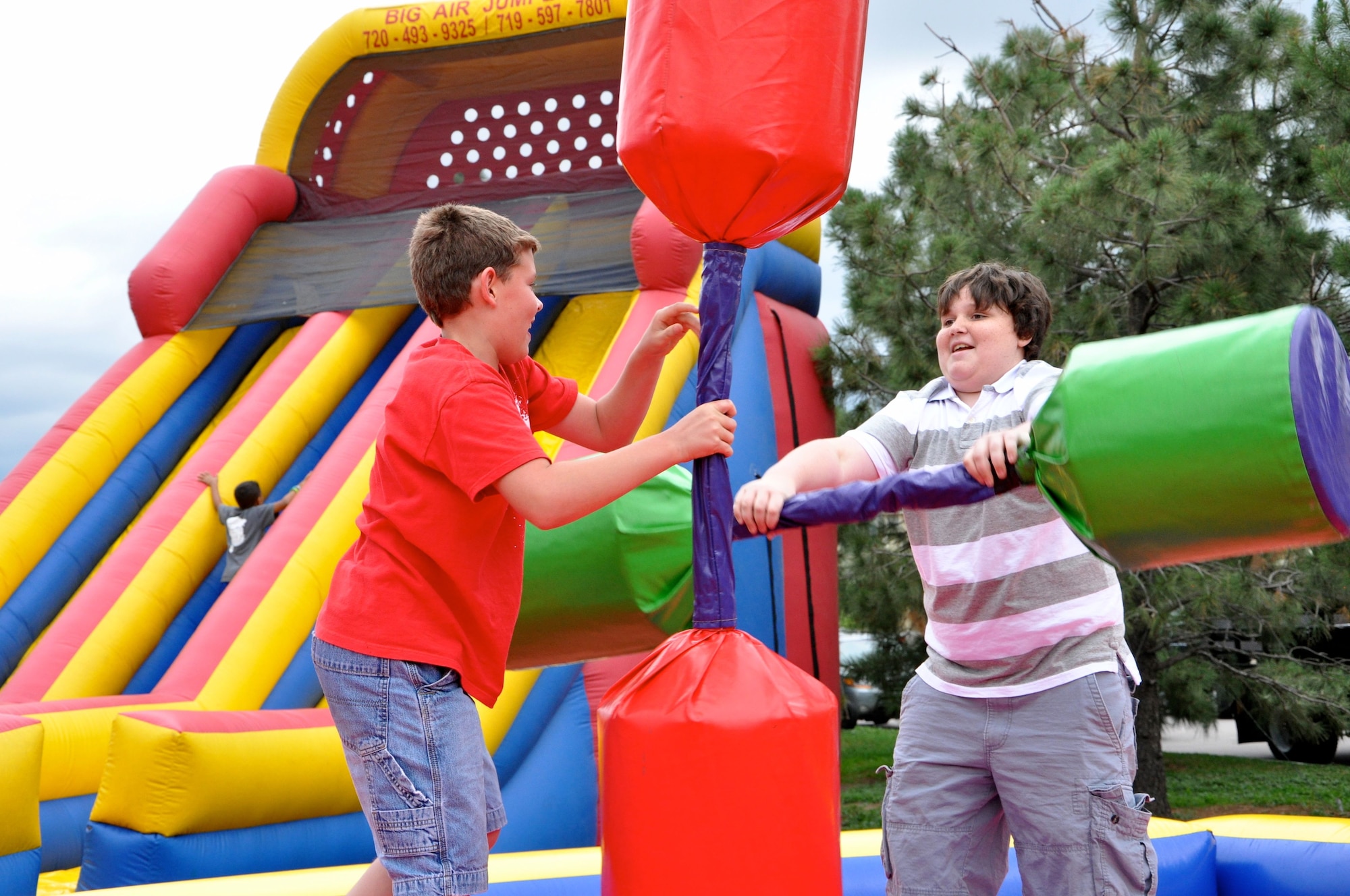 PETERSON AIR FORCE BASE, Colo. – Gary Larsen, son of Tech. Sgt. Erica Larson, 21st Aerospace Medicine Squadron Public Health flight, battles his cousin, Spencer Scott, during the Family Festival and Deployed Families Dinner Aug. 9 at Patriot Park. The dinner and festival included free food, music and carnival activities for all members of Team Pete. (U.S. Air Force photo/1st Lt. Stacy Glaus)