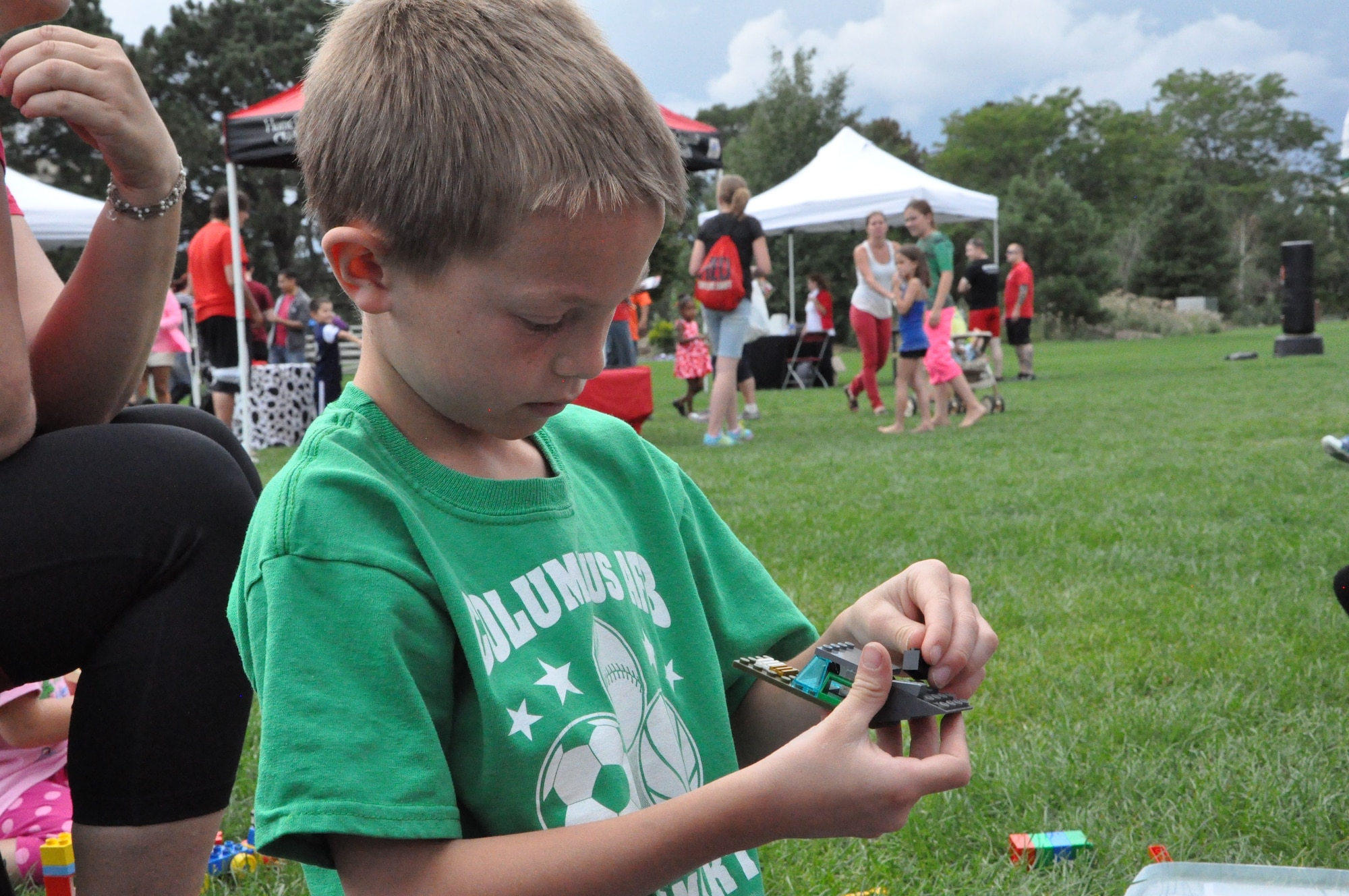 PETERSON AIR FORCE BASE, Colo. – Ben Brooks, son of Jenny and Maj. Rob Brooks, 13th Air Support Operations Squadron, builds a vehicle out of Legos during the Family Festival and Deployed Families Dinner Aug. 9 at Patriot Park. The dinner and festival included free food, music and carnival activities for all members of Team Pete. (U.S. Air Force photo/1st Lt. Stacy Glaus)