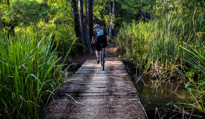 Tech. Sgt. Nathan Swab, 628th Communications Squadron quality assurance evaluator and a Low Country Fat Tire Freaks member, rides across a bridge Aug. 13, 2013, at Marrington Plantation on Joint Base Charleston - Weapons Station, S.C. The Marrington trail system is more than 19 miles long and has an average of 6,000 visitors a year. The LCFTF is a group of volunteers who help maintain the trails. (U.S. Air Force photo/Senior Airman Jared Trimarchi) 