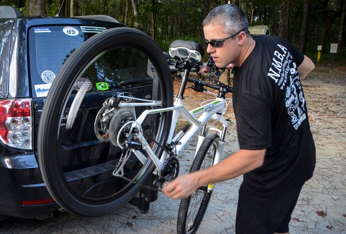 Tech. Sgt. Nathan Swab, 628th Communications Squadron quality assurance evaluator and a Low Country Fat Tire Freaks member, adjusts a friend’s bike  Aug. 13, 2013, at Marrington Plantation on Joint Base Charleston - Weapons Station, S.C. The Marrington trail system is more than 19 miles long and has an average of 6,000 visitors a year. The LCFTF is a group of volunteers who help maintain the trails. (U.S. Air Force photo/Senior Airman Jared Trimarchi) 