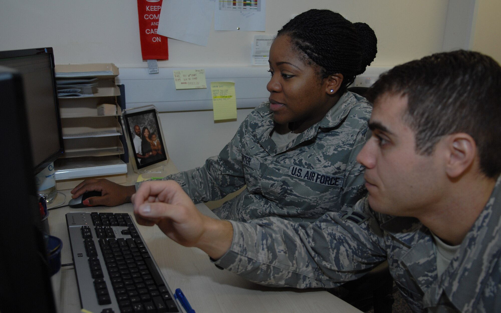 U.S. Air Force Staff Sgt. Brittney Carter, left, 100th Communications Squadron Information Technology Asset Management technician, reviews upgrade training tasks with U.S. Air Force Airman 1st Class Christian Garcia, 100th CS IT Asset Management technician, Aug. 16, 2013, on RAF Mildenhall, England. Carter is being featured on the Square D Spotlight for exhibiting the Air Force Core Value, “Excellence in All We Do.” (U.S. Air Force photo by Airman 1st Class Dillon Johnston/Released)