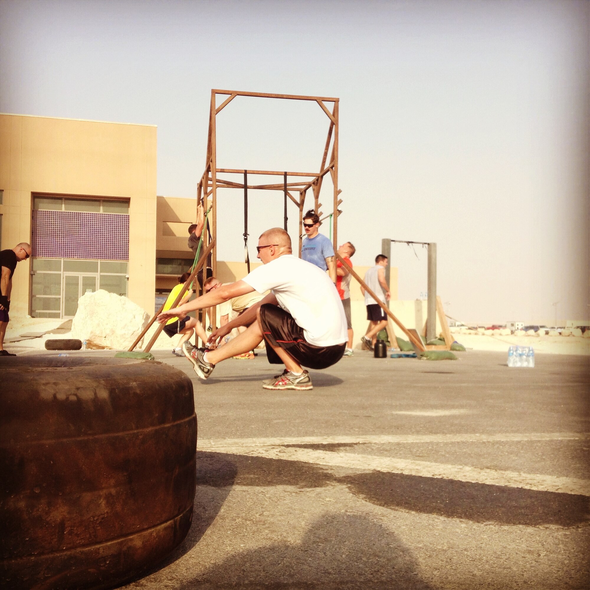 A CrossFitter performs a pistol, or one-legged squat, while others complete pull-ups during the CrossFit Undisclosed workout of the day at the 379th Air Expeditionary Wing in Southwest Asia, Aug. 16, 2013. CrossFit Undisclosed here completes a Hero WOD on the anniversary of the day each Hero was killed. Hero WODs are exceptionally intense, grueling and often lengthy workouts that will push your body to its utmost limit, and each WOD is named for a specific individual who was killed in the line of duty, policemen, firefighters and service members alike. (U.S. Air Force photo/1st Lt. Susan Harrington)