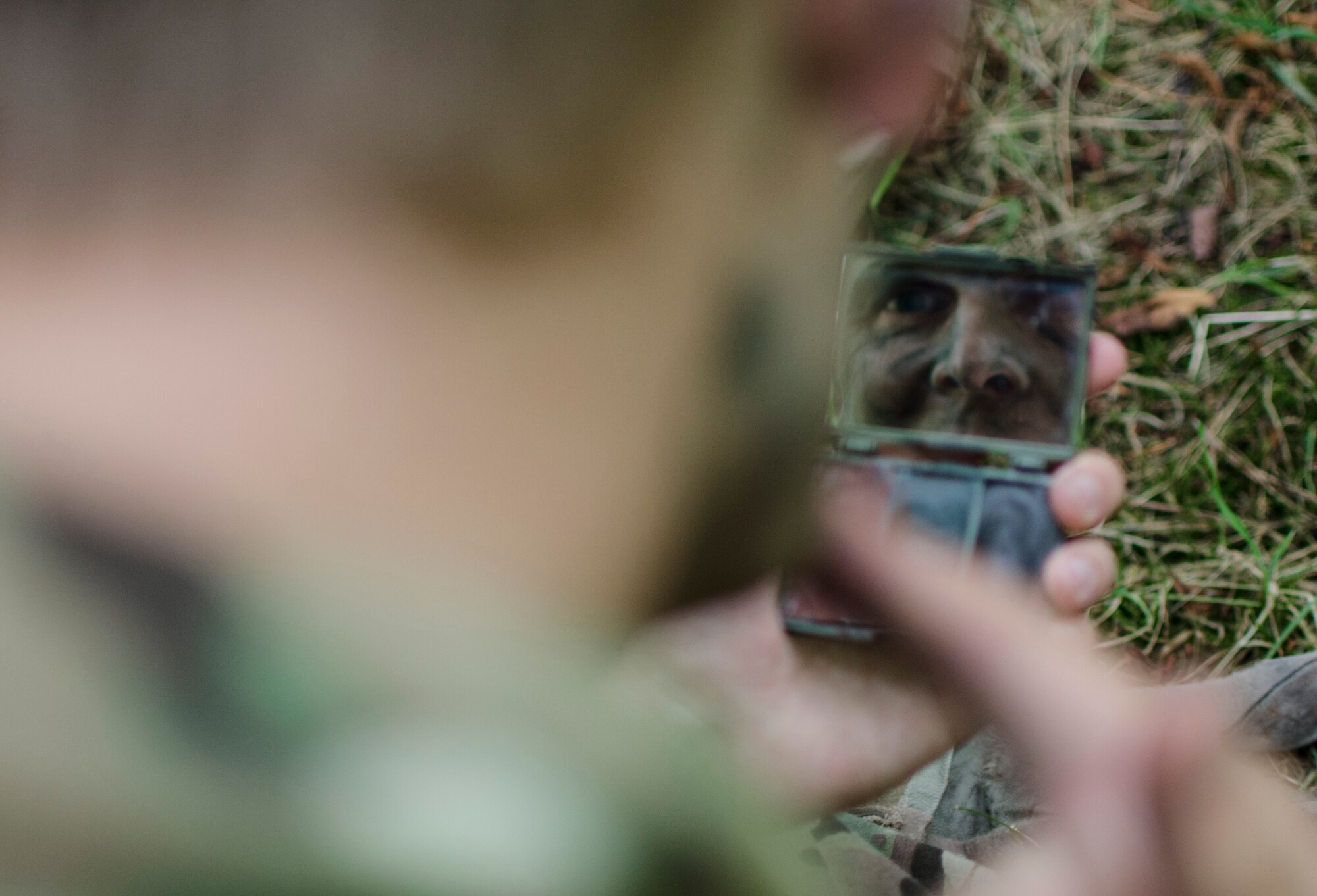 Staff Sgt. John Gabel, 7th Special Operations Squadron MC-130H Combat Talon II flight engineer, puts on camouflage during combat survival training at Stanford Training Area, England, Aug. 6, 2013. The training covered other aspects of combat survival such as land navigation and evasion tactics. (U.S. Air Force photo by Staff Sgt. Stephen Linch)