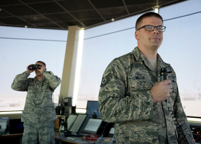 Tech. Sgt. Thomas Miller clears an aircraft for takeoff as Senior Airman Kevin Krippner surveys the flightline at the 379th Air Expeditionary Wing in Southwest Asia, Aug. 13, 2013. Miller is the 379th Expeditionary Operations Support Squadron air traffic control watch supervisor deployed from Whiteman Air Force Base, Mo., and hails from Olathe, Kan. Krippner is a 379th EOSS air traffic controller deployed from Holloman Air Force Base, N.M., and a Winchester, Va., native. (U.S. Air Force photo/Senior Airman Bahja J. Jones) 