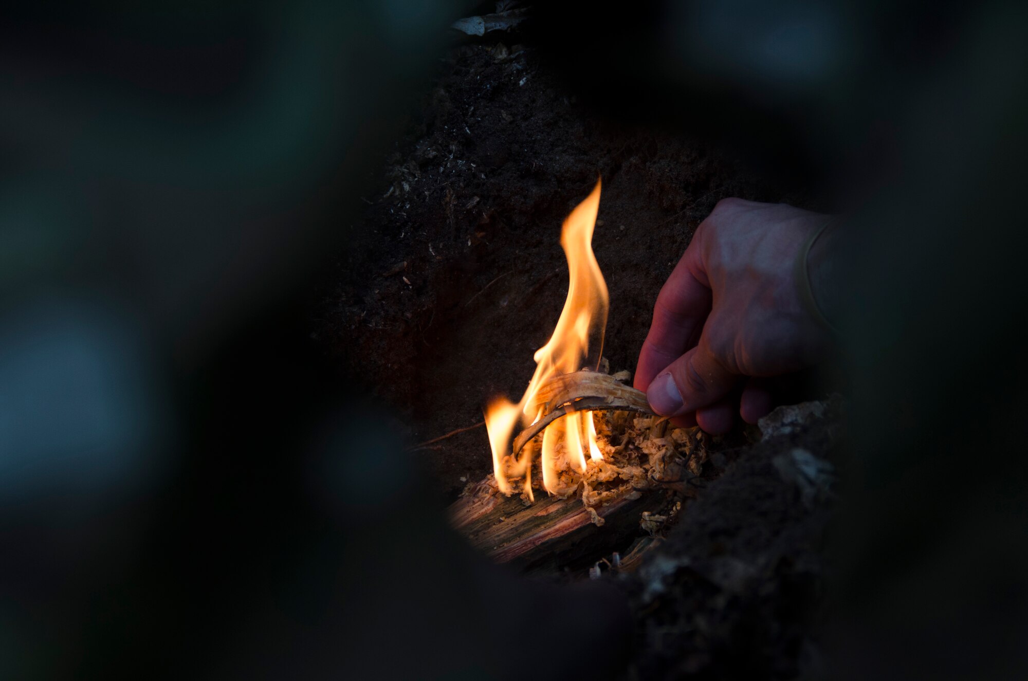 Staff Sgt. Jacob Schmidt, 352nd Special Operations Support Squadron survival, evasion, resistance and escape specialist, shows Airmen from the 352nd Special Operations Group how to make a fire during combat survival training at Stanford Training Area, England, Aug. 6, 2013. The training covered other aspects of combat survival such as land navigation and evasion tactics. (U.S. Air Force photo by Staff Sgt. Stephen Linch)