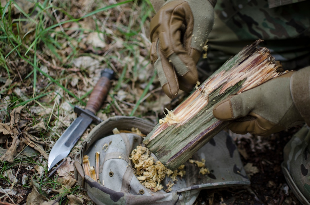 Staff Sgt. Jacob Schmidt, 352nd Special Operations Support Squadron survival, evasion, resistance and escape specialist, shows Airmen from the 352nd Special Operations Group how to build a fire during combat survival training at Stanford Training Area, England, Aug. 6, 2013. The training covered other aspects of combat survival such as land navigation and evasion tactics. (U.S. Air Force photo by Staff Sgt. Stephen Linch)