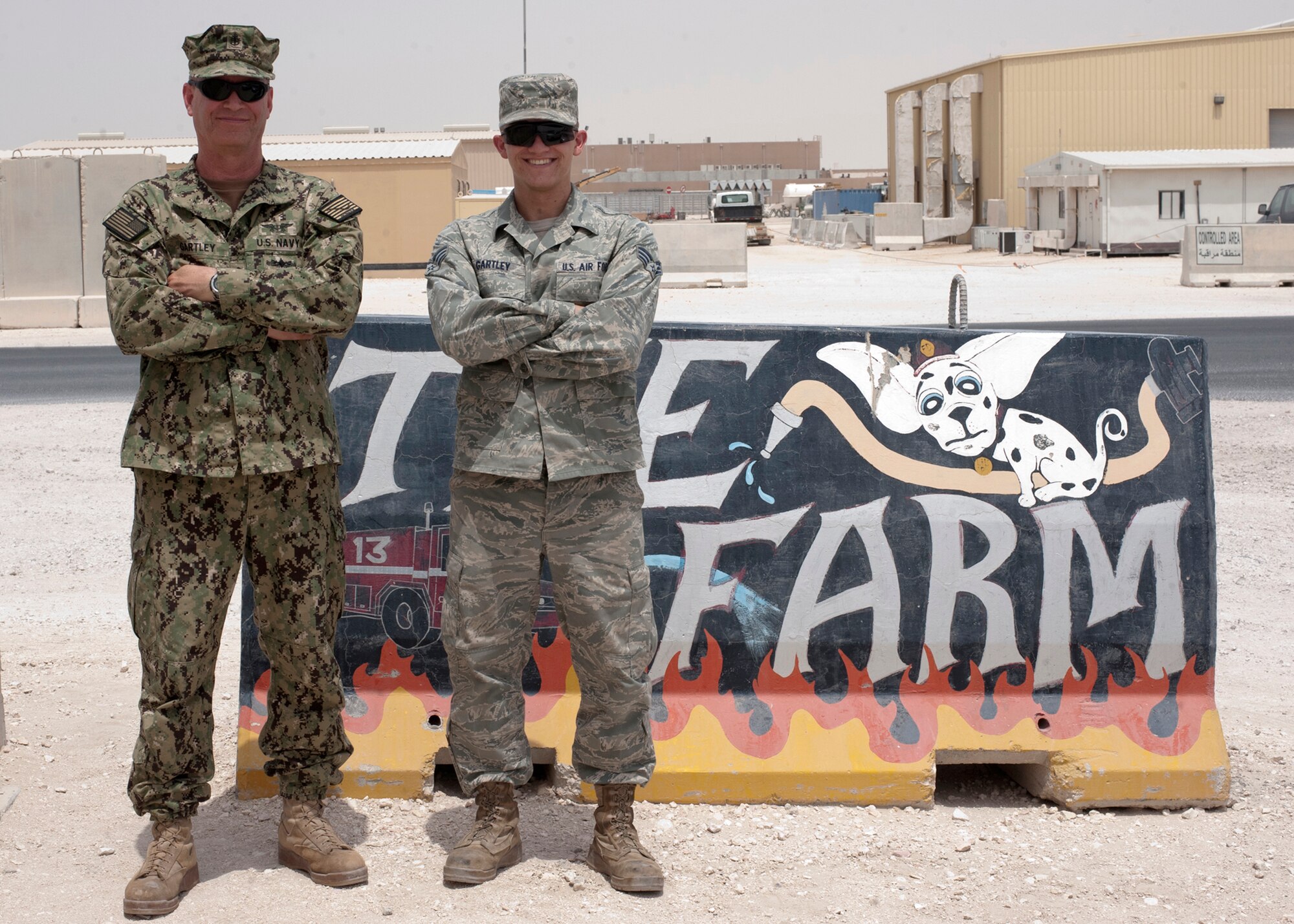 Navy Chief Petty Officer Glen Gartley poses alongside his nephew, Senior Airman Ross Gartley, at the 379th Air Expeditionary Wing in Southwest Asia, Aug. 9 2013. The two were coincidentally deployed together supporting missions at the 379th AEW here and the Chief said he enjoyed the shared deployment experience as it gave him an opportunity to give his nephew insight on the Navy operations.  (U.S. Air Force photo/Senior Airman Bahja J. Jones) 