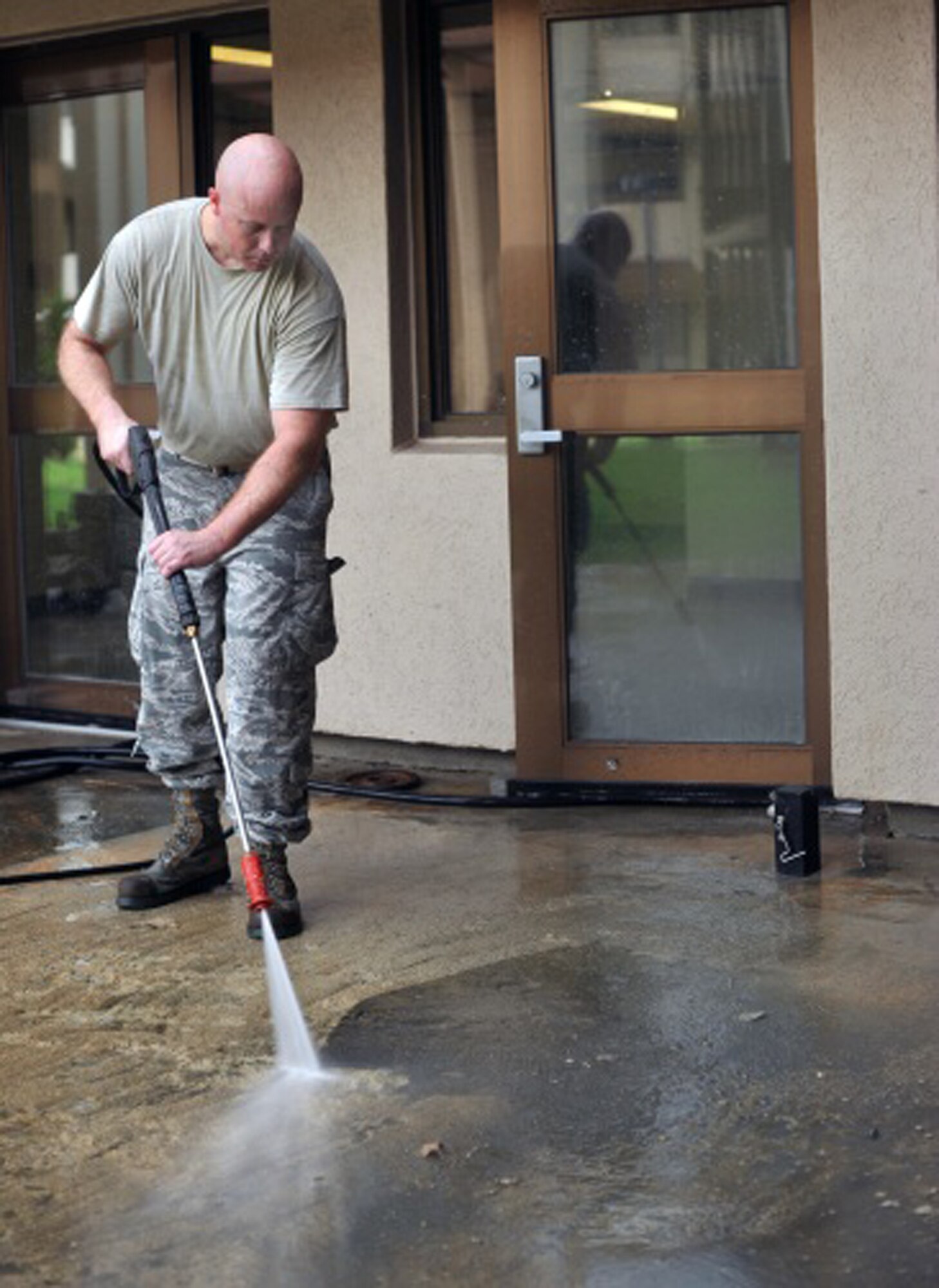 Tech. Sgt. Taylor Vandenboogaard, 51st Civil Engineer Squadron zone manager, pressure washes the patio of Bld. 1349 during the 51st CES worst dorm first project Aug. 16, 2013 at Osan Air Base, Republic of Korea. Seventy-five Airmen assisted with the CES renovation project at the dorm. (U.S. Air Force photo/Senior Airman Kristina Overton)