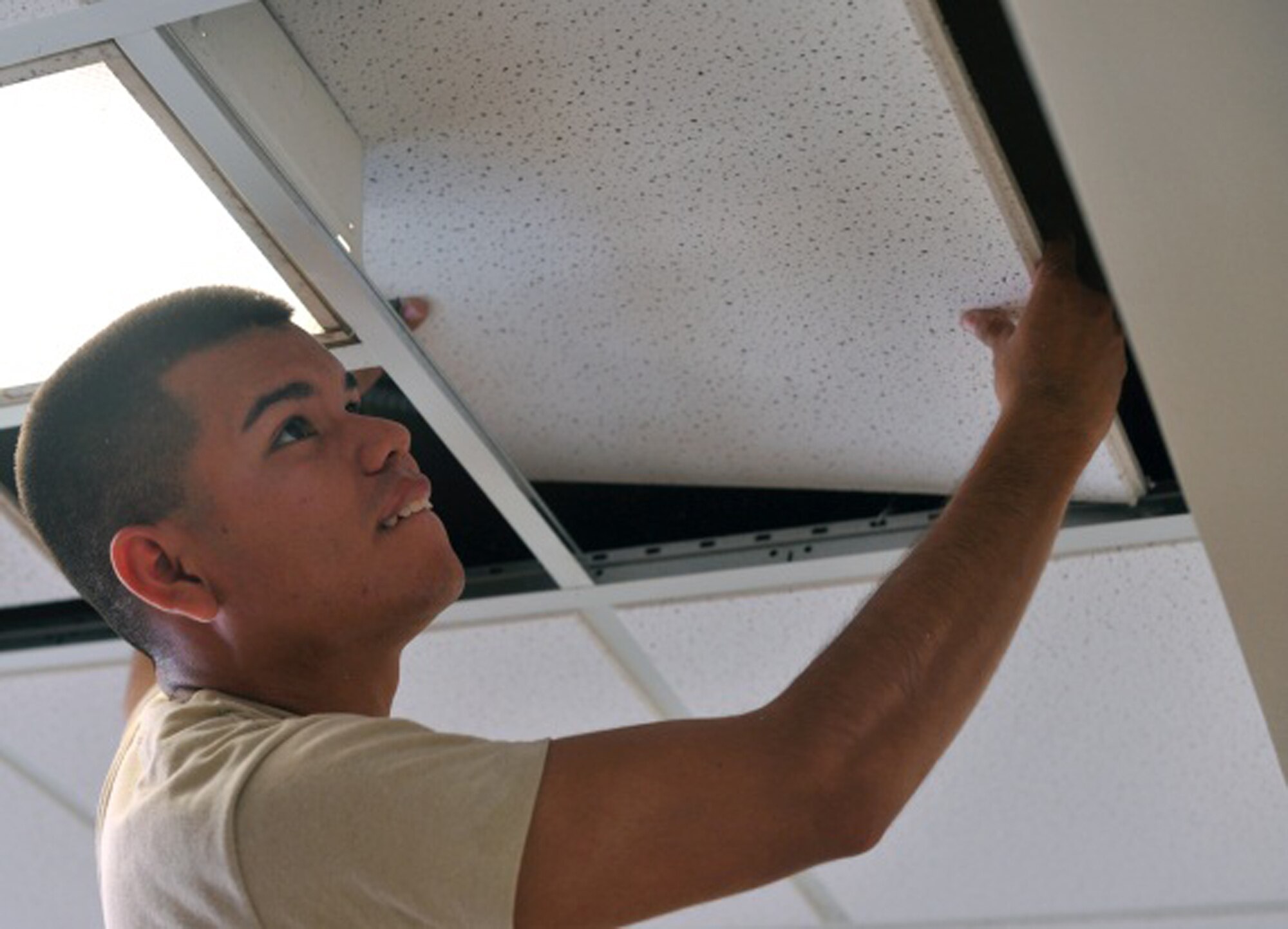 Senior Airman Guerddy Espinoza, 51st Civil Engineer Squadron member, replaces a ceiling panel in the day room of Bld. 1349 during the 51st CES worst dorm first project Aug. 16, 2013 at Osan Air Base, Republic of Korea. The day room also received a fresh coat of paint, and cabinet and interior refurbishments. (U.S. Air Force photo/Senior Airman Kristina Overton)