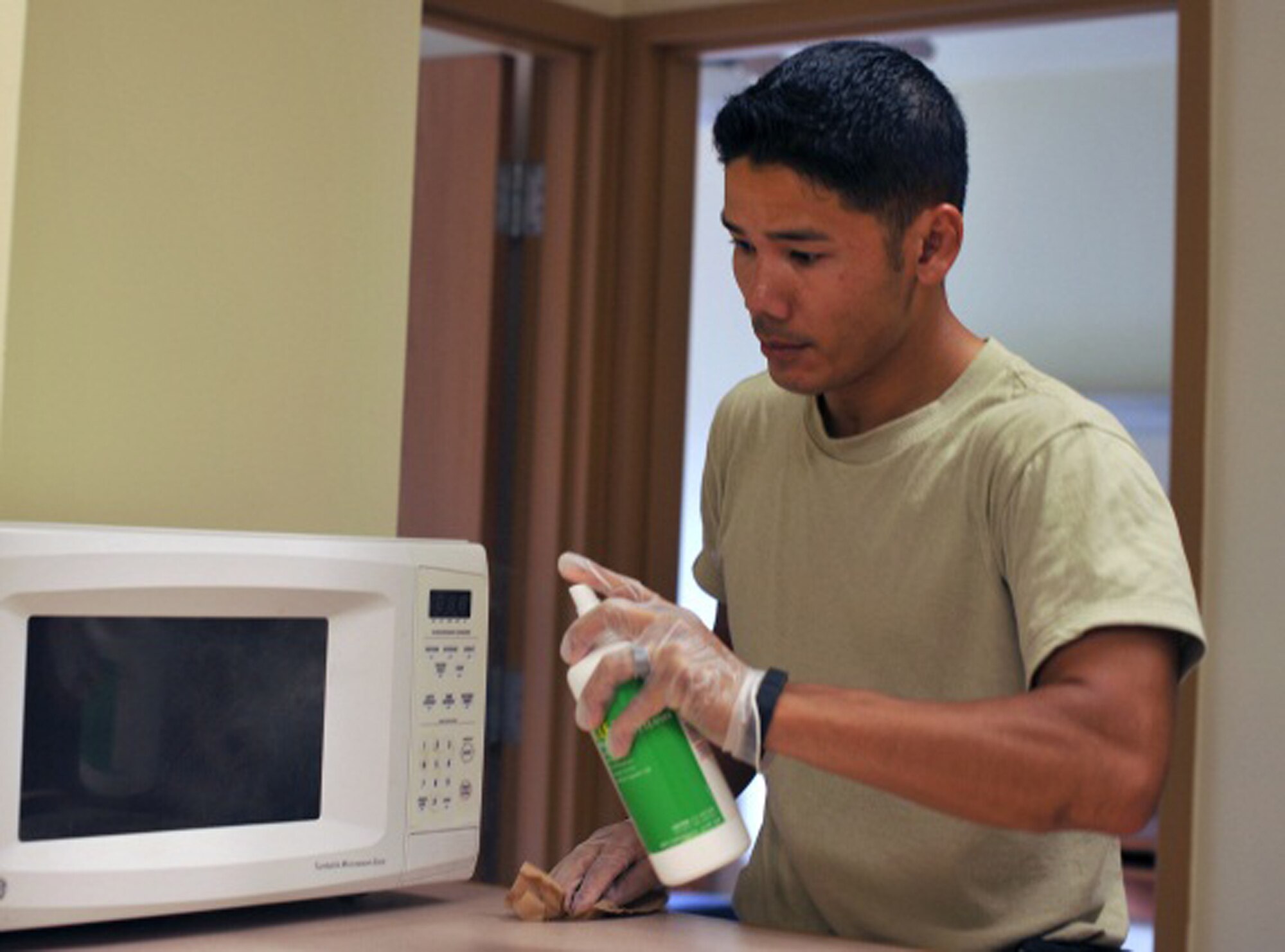 Tech. Sgt. Samnang Lay, 51st Civil Engineer Squadron member, cleans a microwave and kitchen area of one of the dorms in Bldg. 386, during the 51st CES worst dorm first project Aug. 16, 2013 at Osan Air Base, Republic of Korea. Another 14 Airmen worked at Bldg. 386, ensuring vacant rooms were move-in ready, and also doing upgrades to the exterior of the dorm. (U.S. Air Force photo/Senior Airman Kristina Overton)