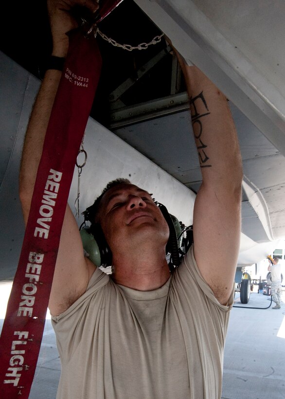 Tech. Sgt. Derrick Melrose installs a ground safety device on a KC-135 Stratotanker during a thru flight inspection at the 379th Air Expeditionary Wing in Southwest Asia, Aug. 13, 2013. Melrose is a 340th Expeditionary Aircraft Maintenance Unit crew chief deployed from General Mitchell Air National Guard Base, Wis., and hails from Bristol,Wis. (U.S. Air Force photo/Senior Airman Bahja J. Jones)  