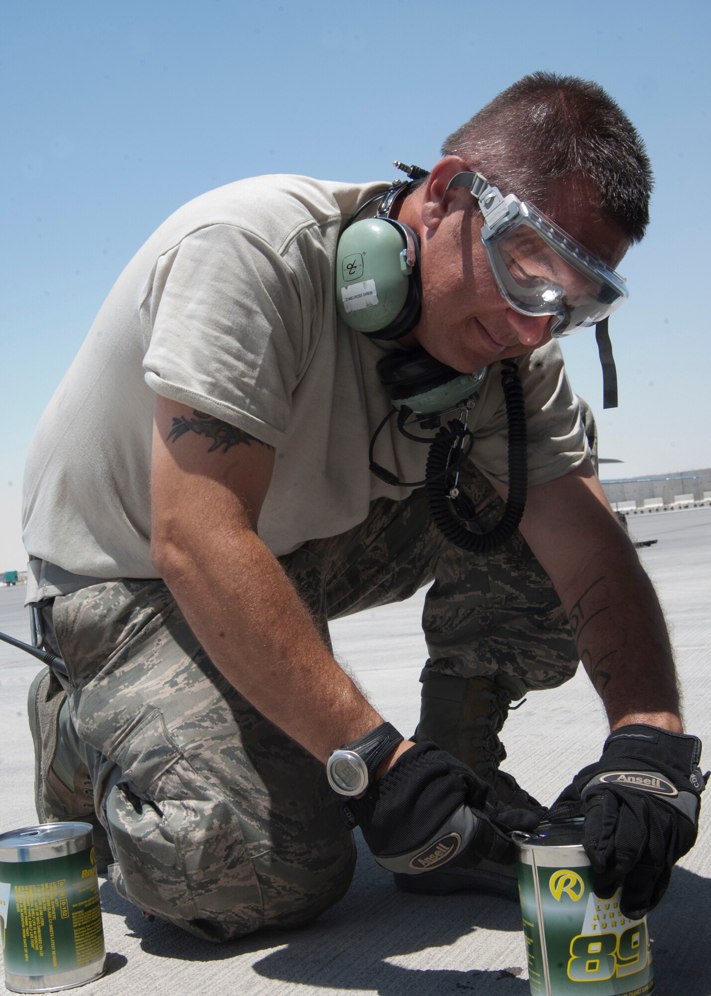 Tech. Sgt. Derrick Melrose opens a can of oil before pouring it into a KC-135 Stratotanker engine during a thru flight inspection at the 379th Air Expeditionary Wing in Southwest Asia, Aug. 13, 2013. Melrose is a 340th Expeditionary Aircraft Maintenance Unit crew chief deployed from General Mitchell Air National Guard Base, Wis., and hails from Bristol, Wis. (U.S. Air Force photo/Senior Airman Bahja J. Jones)