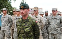 Canadian Forces Capt. Patrick Reid, an engineer with 1 Engineer Support Unit, Joint Operational Support Group out of Kingston, Ontario, leads a multinational formation of U.S. Marines from 9th Engineer Support Battalion and Washington Army National Guard soldiers with 96th Troop Command, during a ribbon-cutting ceremony for the newly renovated Erdmiin Orgil School in Nalaikh district, Ulaanbaatar, Mongolia, Aug. 13. The project took place as part of exercise Khaan Quest 2013. Engineers from the U.S., Mongolia and Canada worked side-by-side to replace the roof, windows, front stairs and interior doors, "re-stucco" the exterior walls, apply emulsion and repaint the building. They also tore down a structurally unsound concrete awning at the main entrance and built a handicap-accessible ramp at the front of the school.  