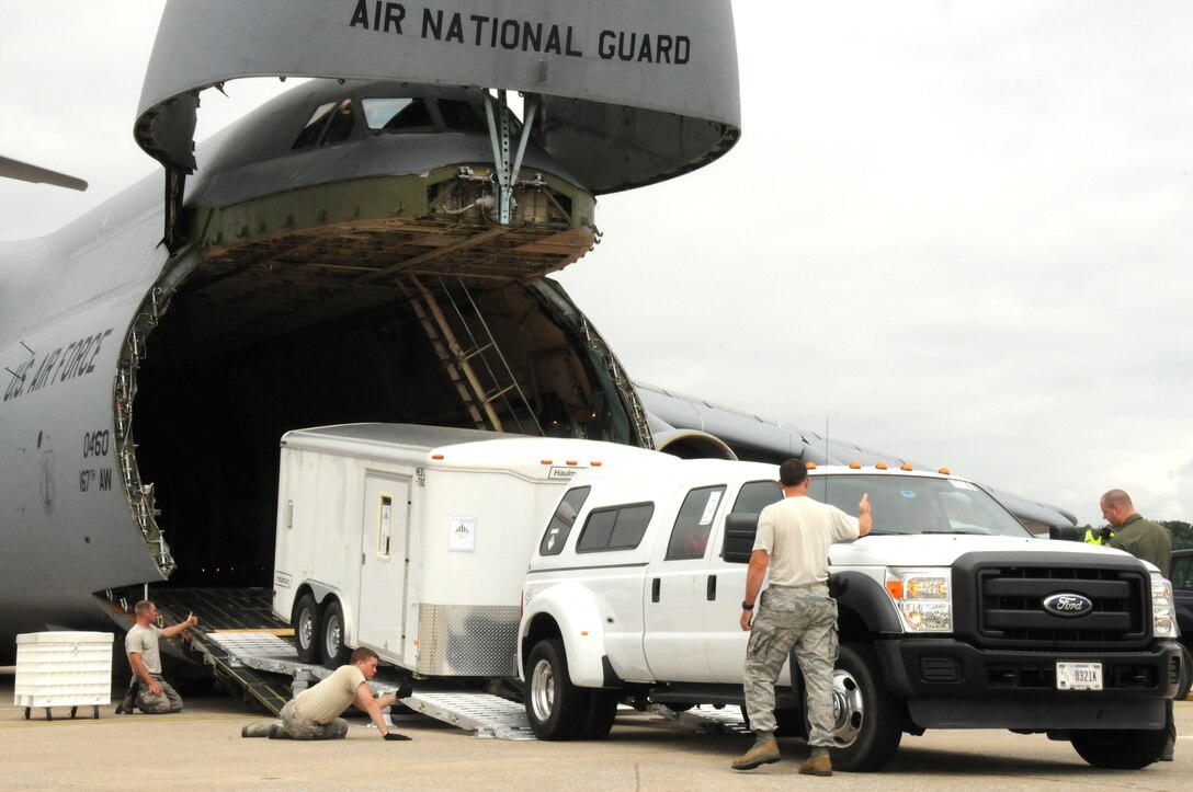 Members of Pennsylvania's Homeland Response Force Team from the 193rd Special Operations Wing begin loading one of five trucks and trailers full of medical supplies on a C-5 from the 167th Airlift Wing, Martinsburg, W.V. The exercise was designed to test the regional HRF's ability to collaborate in response to potential chemical, biological, radiological, nuclear and high-yeiled explosive situations. (U.S. Air National Guard photo by Staff Sgt. Susan Penning/Released)