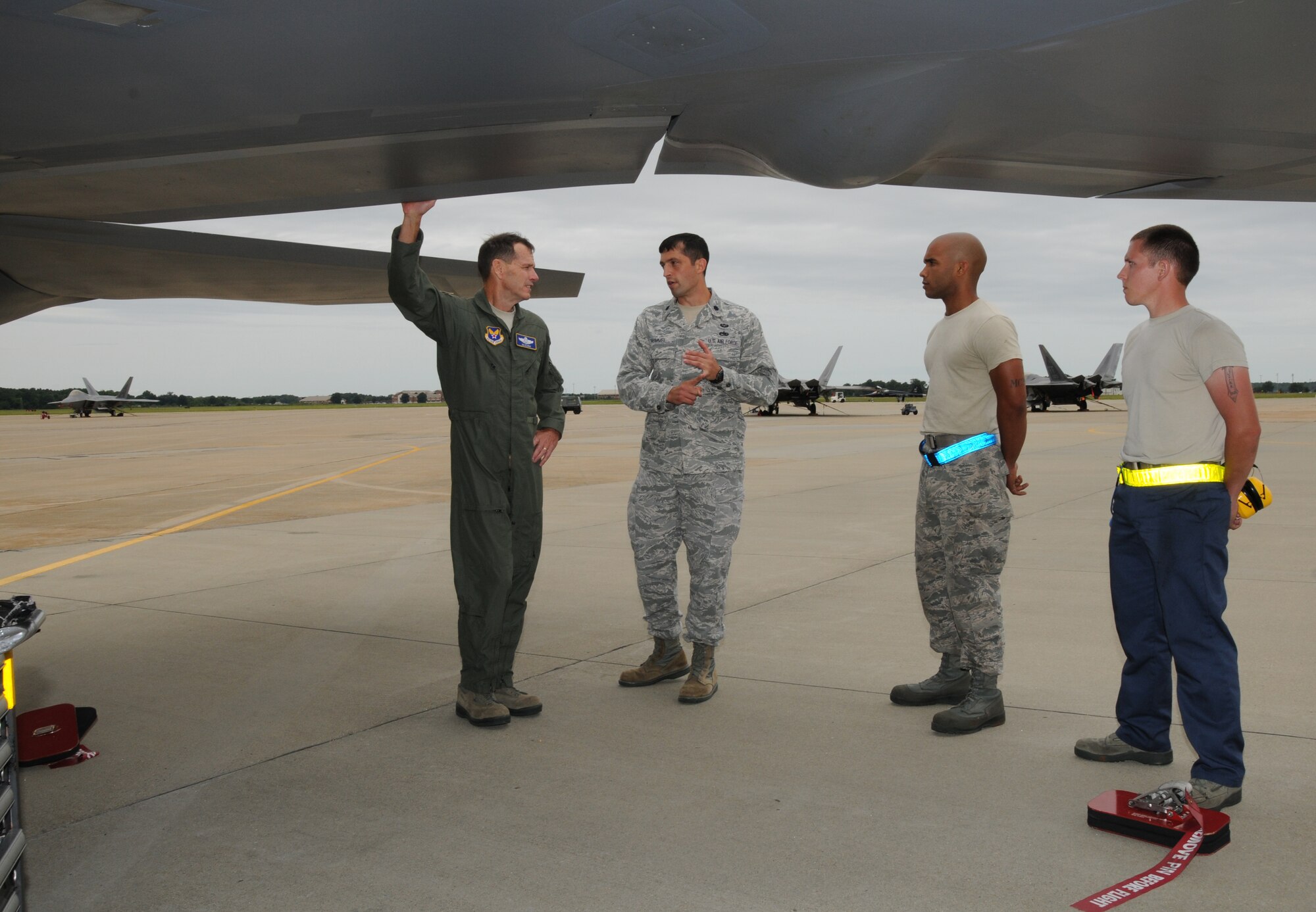 Lt. Gen. Stanley E. Clarke III (left), director of the Air National Guard, receives a briefing on the capabilities of the F-22 Raptor from Lt. Col. Mathew R. Hummel (l-r), 192d Fighter Wing Aircraft Maintenance Squadron Commander, Airman First Class Ismael T. Debarros and Senior Airman Daniel W. Stewart from the 1st Fighter Wing Aircraft Maintenance Squadron, Joint Base Langley-Eustis Hampton, Va., Aug. 16. Gen. Clarke visited with Airmen while visiting JBLE.  (U.S. Air National Guard photo by MSgt. Carlos Claudio).