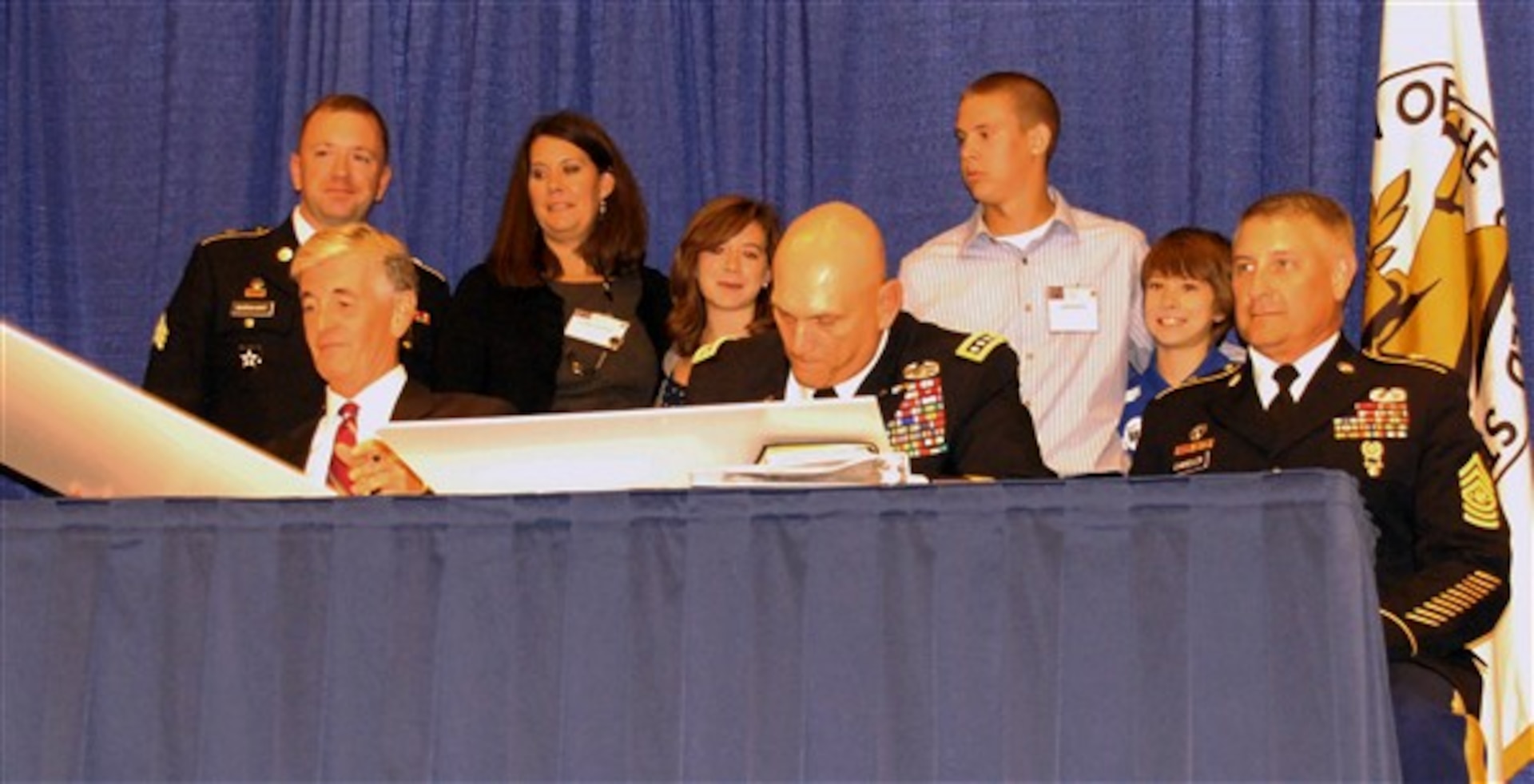 Army Secretary John M. McHugh, Army Chief of Staff Gen. Raymond T. Odierno and Sgt. Maj. of the Army Raymond F. Chandler III, sign the Army Family Covenant, Oct. 10, 2011, as wounded warrior Army Sgt. Jeremy Barnhart and his family look on. The Barnhart family was honored as the Association of the U.S. Army’s volunteer family of the year.