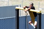 A candidate in the California National Guard's Grizzly Youth Program gets above ground to tie a rope knot July 20, 2011, during an obstacle challenge at Camp San Luis Obispo, Calif.