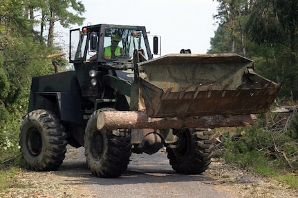 The Virginia National Guard's Army Spc. Bradley Dial operates a scoop loader to clear trees from a road after Hurricane Isabel in 2003.