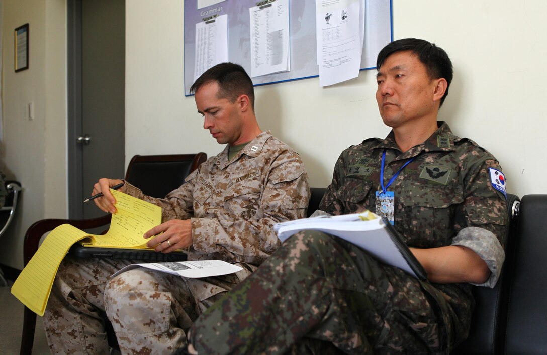 U.S. Marine Capt. Albert Bellamy and Republic of Korea Army Col. Seoko Yoon listen to a brief during Khaan Quest's command post exercise, Aug. 12. Khaan Quest, a multinational peacekeeping exercise hosted annually by the Mongolian Armed Forces and co-sponsored by U.S. Marine Corps Forces Pacific and U.S. Army Pacific, is the latest in a continuing series of exercises designed to promote regional peace and security. MARFORPAC is the U.S. executive for this year’s exercise, which has been taking place since 2003. Khaan Quest 2013 officially ended Aug. 14. Bellamy, serving as a battalion operations officer for 2nd Battalion, 11th Marine Regiment during the CPX, is from Wadsworth, Ohio. Yoon served as the civil-military affairs officer for the multinational brigade's headquarters.