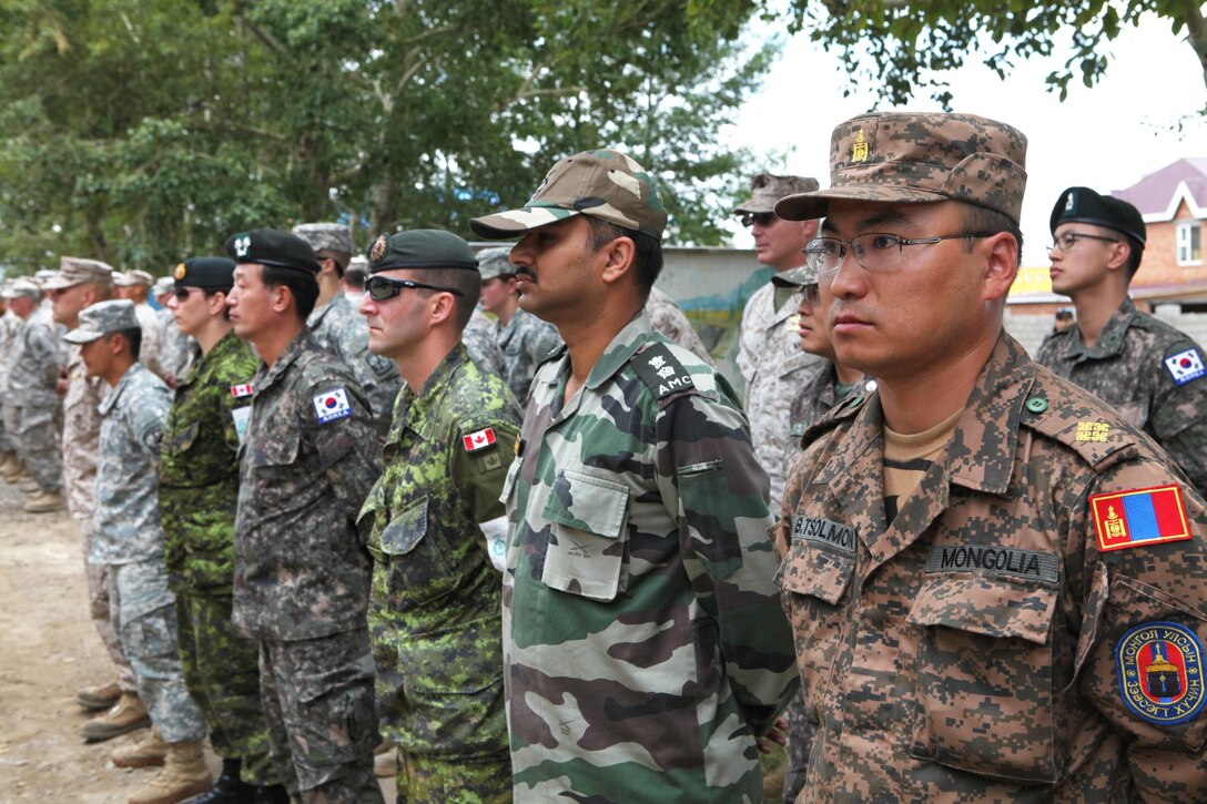 Military medical professionals from Mongolia, India, Canada, the Republic of Korea and the U.S. stand in a multilateral formation at the Cooperative Health Engagement and Subject Matter Expert Exchange closing ceremony in Nalaikh district, Ulaanbaatar, Mongolia, Aug. 13. The medical portion of this year’s Khaan Quest exercise expanded on those of previous exercises by striking more of a balance between classroom learning and practical experience, giving the multinational team of doctors an opportunity to work together through real-life, clinical situations. Khaan Quest is an annual peacekeeping operations-focused, combined training exercise hosted annually by the Mongolian Armed Forces, and co-sponsored by U.S. Army Pacific and U.S. Marine Corps Forces, Pacific. MARFORPAC served as the U.S. executive agent for Khaan Quest 2013.