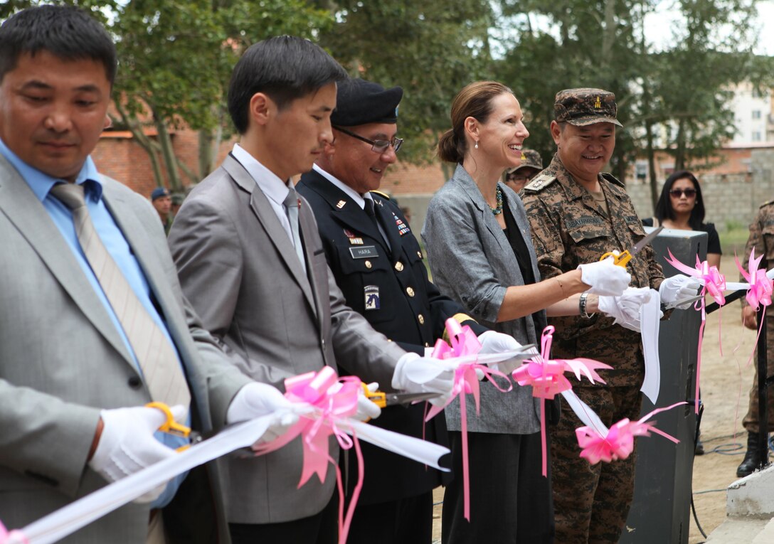(From right) Maj. Gen. B. Bayarmagnai, deputy chief of general staff for the Mongolian Armed Forces, U.S. Ambassador to Mongolia Piper Campbell and Maj. Gen. Gary Hara, deputy commanding general of the Army National Guard for U.S. Army Pacific, cut the ribbon for newly renovated Erdmiin Orgil School in Nalaikh district, Ulaanbaatar, Mongolia, Aug. 13. The project took place as part of exercise Khaan Quest 2013. Engineers from the U.S., Mongolia and Canada worked side-by-side to replace the roof, windows, front stairs and interior doors, "re-stucco" the exterior walls, apply emulsion and repaint the building. They also tore down a structurally unsound concrete awning at the main entrance and built a handicap-accessible ramp at the front of the school.
