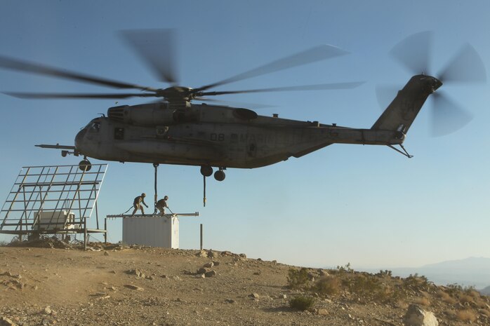 A CH-53E hovers and prepares to extract a container out of Observation Post Crampton in the Combat Center's training area Aug. 13, 2013. Marines with Combat Logistics Battalion 7 and HMH-366 extracted communication gear. The units used the extraction as a training exercise.