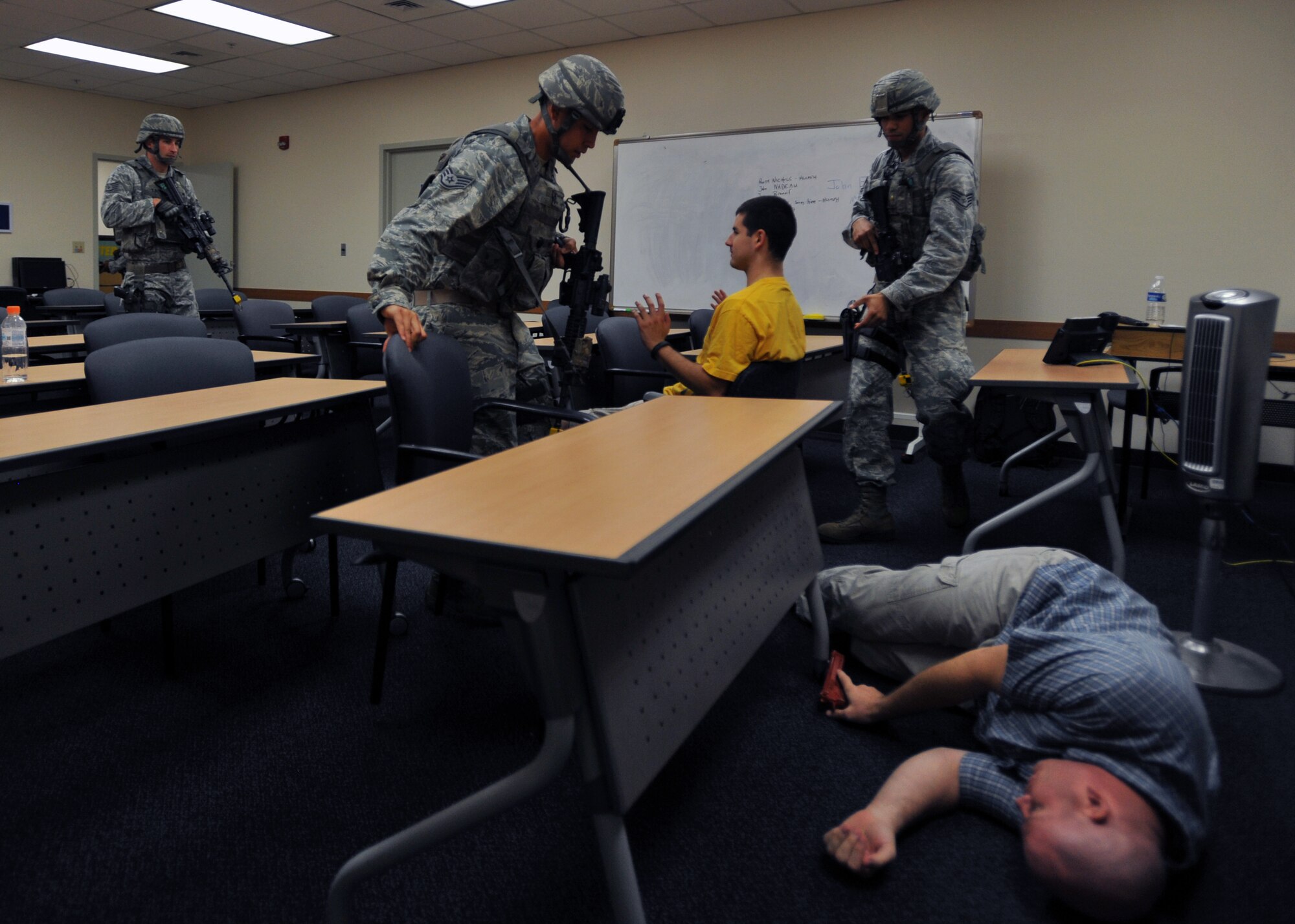 Members of the 51st Security Forces Squadron approach a role player posing as a hostage in a back room of the Exchange during a high risk response training scenario at Osan Air Base, Republic of Korea, Aug. 16, 2013. The high risk response training also included classroom instruction and dry-fire exercises. (U.S. Air Force photo/Senior Airman Siuta B. Ika)