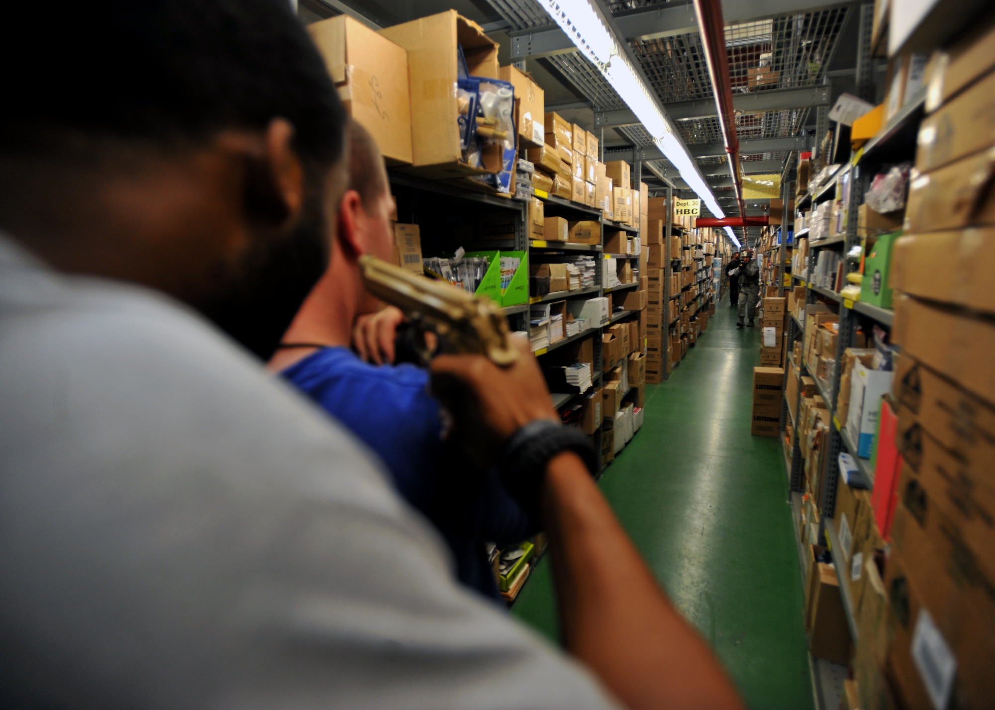 Role players posing as a gunman and hostage react to members of the 51st Security Forces Squadron in the stock room of the Exchange at Osan Air Base, Republic of Korea, Aug. 16, 2013. The scenario was one of many that Osan defenders participated in to sharpen their high risk response skills. (U.S. Air Force photo/Senior Airman Siuta B. Ika)