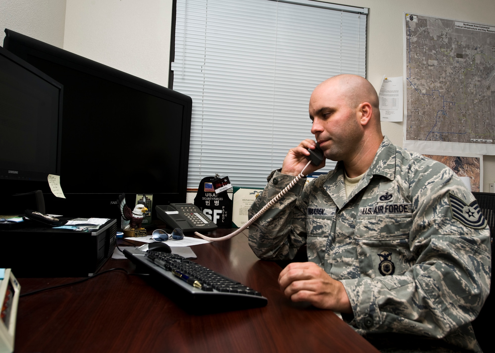 Tech. Sgt. Brady Warren, 99th Security Forces Squadron criminal intelligence analyst, answers a phone call Aug. 15, 2013, at Nellis Air Force Base, Nev. Warren was selected by the Nellis First Sergeants to receive the Diamond Sharp award for the month of July.  Warren has completed six credit hours towards his bachelor’s degree in Criminal Justice, maintains a 3.5 GPA and is eight classes away from graduation.  Warren also attended the Air Combat Command Criminal Intelligence Analyst Training course. (U.S. Air Force photo by Airman 1st Class Jason Couillard)