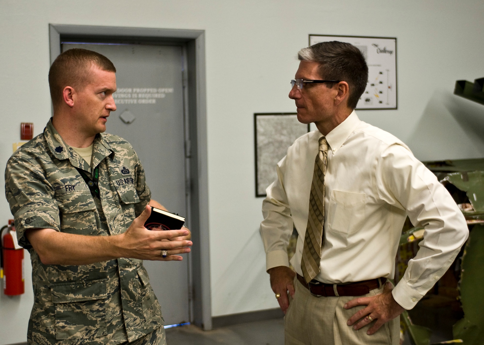 Lt. Col. William Fry, 547th Intelligence Squadron commander, speaks to Congressman Joe Heck during a visit to the threat training facility, Aug. 13, 2013, at Nellis Air Force Base, Nev. Heck visited Nellis to discuss important topics. Heck has more than 25 years in public service as a physician, Army Reservist, and community volunteer. Heck served as a volunteer firefighter and ambulance attendant, Search & Rescue team member, and SWAT physician. Heck is also a Colonel in the U.S. Army Reserve, and has been on three active duty deployments. (U.S. Air Force photo by Airman 1st Class Jason Couillard)