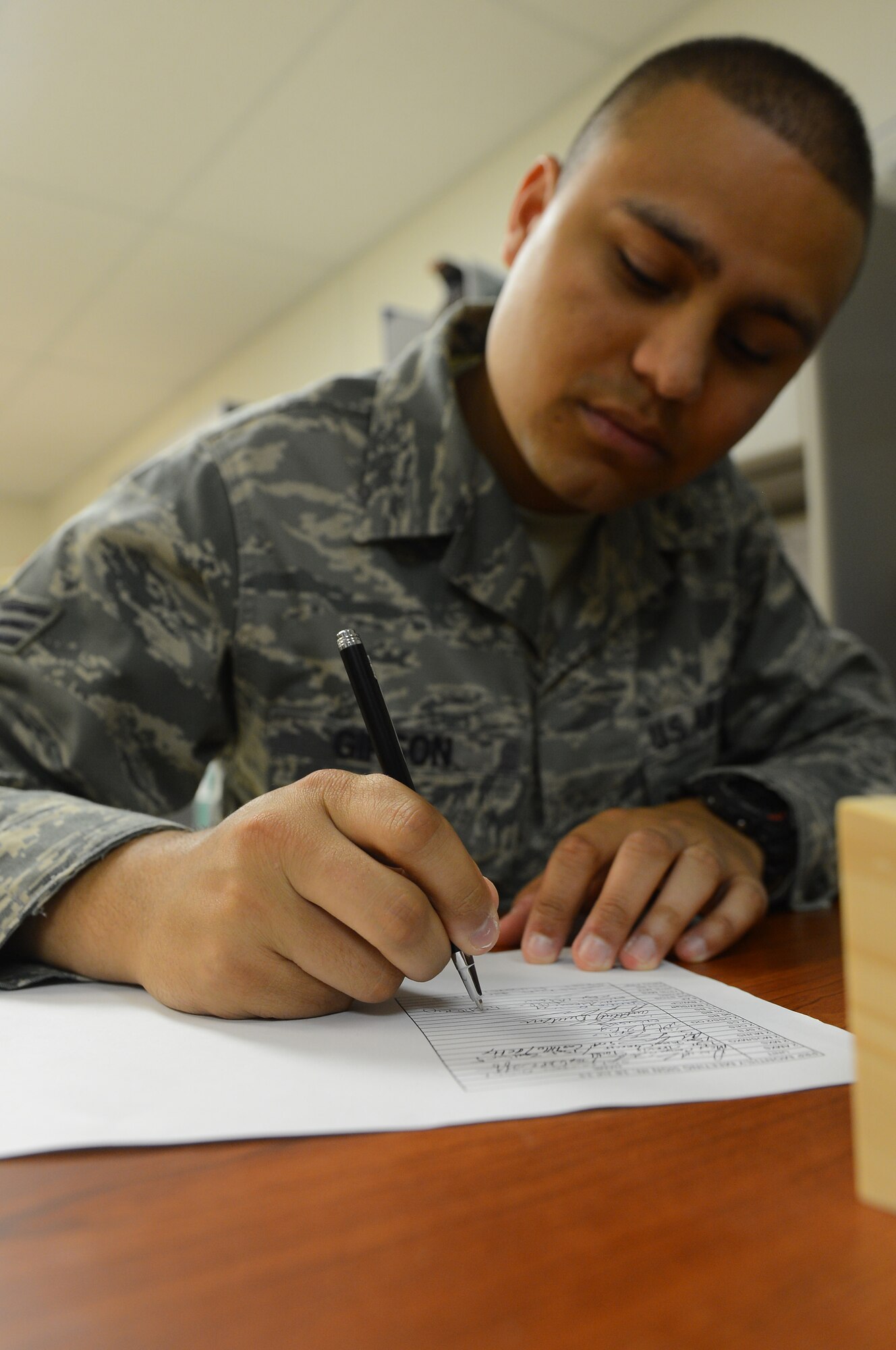 Senior Airman Timothy Gipson, 2nd Bomb Wing Staff personnel reliability program technician, signs a form verifying his attendance for a monthly PRP meeting on Barksdale Air Force Base, La., Aug. 19, 2013. The installation PRP monitor holds monthly meetings to pass on any new guidance or regulations so all PRP technicians will be in compliance. (U.S. Air Force photo/Senior Airman Micaiah Anthony)
