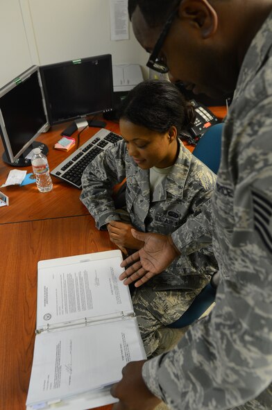 Tech Sgt. LaSabra Johnson, 2nd Bomb Wing Staff personnel reliability program NCO in-charge, goes through a training book with Airman 1st Class Jocelyn Allen, 2nd BW Staff PRP technician, on Barksdale Air Force Base, La., Aug. 19, 2013. Airmen from the PRP section monitor all PRP sections around the base and ensure all PRP Airmen are certified to carry out the mission.  (U.S. Air Force photo/Senior Airman Micaiah Anthony)