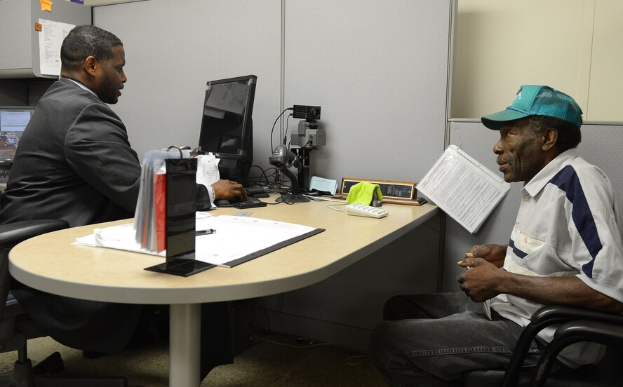 George King, 2nd Force Support Squadron military personnel section verifying official, makes a new military ID card for Ret. Army Sgt. Joe George in the Customer Service office on Barksdale Air Force Base, La., Aug. 19, 2013. The Customer Service office assists military members, dependents and retirees with official passports, updating citizenships, awards and decorations, IDs, special leave and dependency determination. (U.S. Air Force photo/Senior Airman Micaiah Anthony)