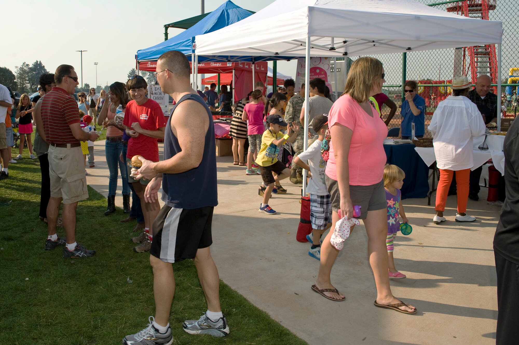 Members of Team Buckley enjoy food and activities during Fun Fest Aug. 13, 2013, at the softball fields on Buckley Air Force Base. The Fun Fest community fair is an annual celebration that included booths from various community groups, base agencies, and free food. (U.S. Air Force photo by Senior Airman Phillip Houk/Released)