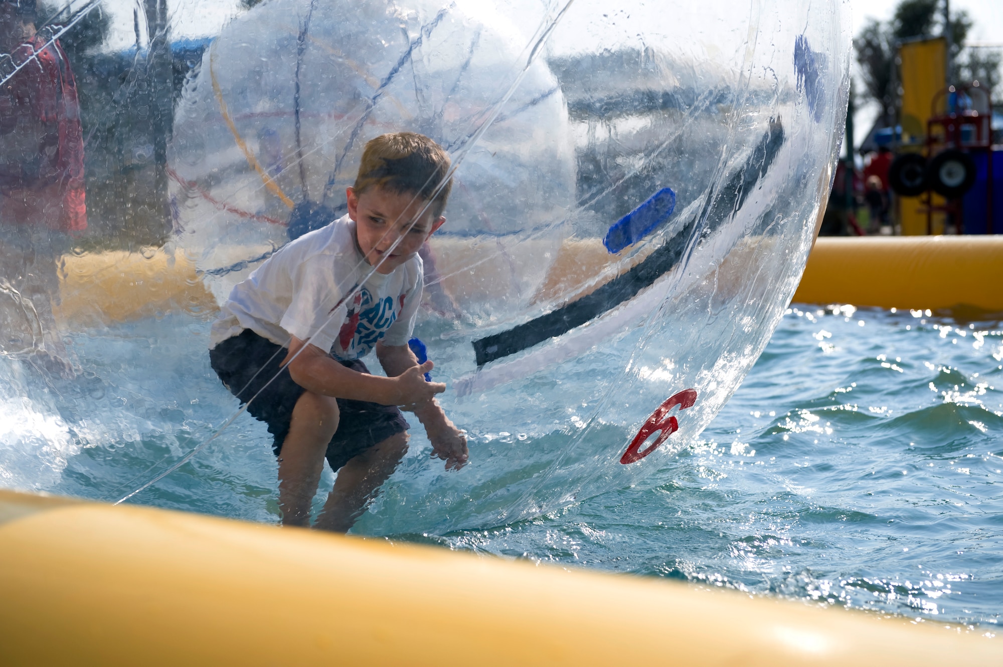 The son of a 460th Space Communications Squadron member walks on top of water while inside of a water ball during Fun Fest Aug. 13, 2013, at the softball fields on Buckley Air Force Base, Colo.  Fun Fest is Buckley’s annual birthday celebration which includes a field day and community fair. (U.S. Air Force photo by Senior Airman Phillip Houk/Released)